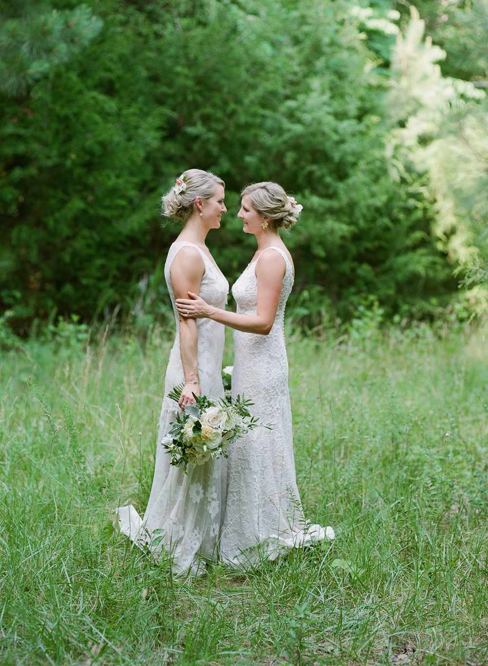 paige and kristine wedding brides embracing in field