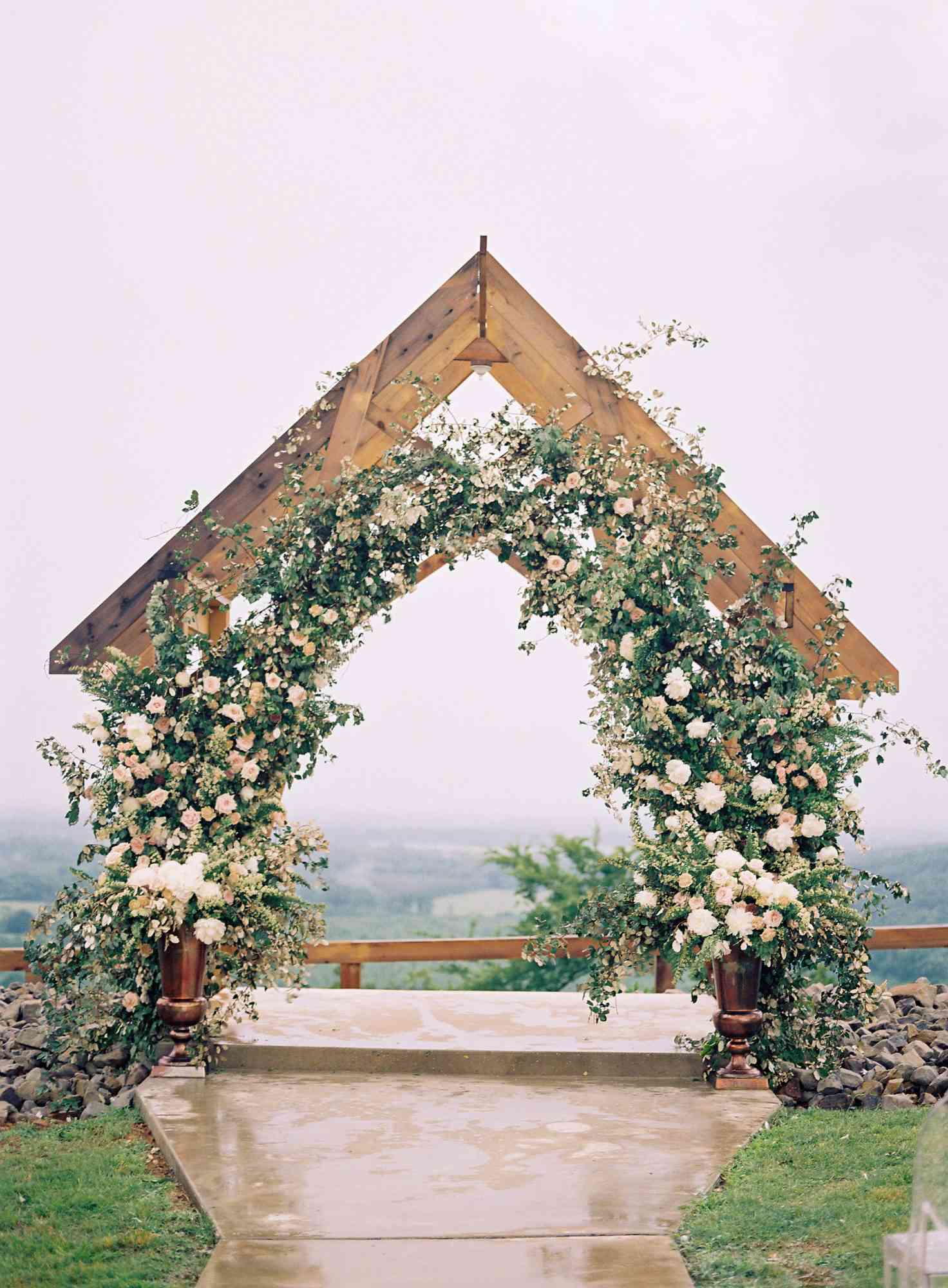 wedding archway with greenery and floral river valley view