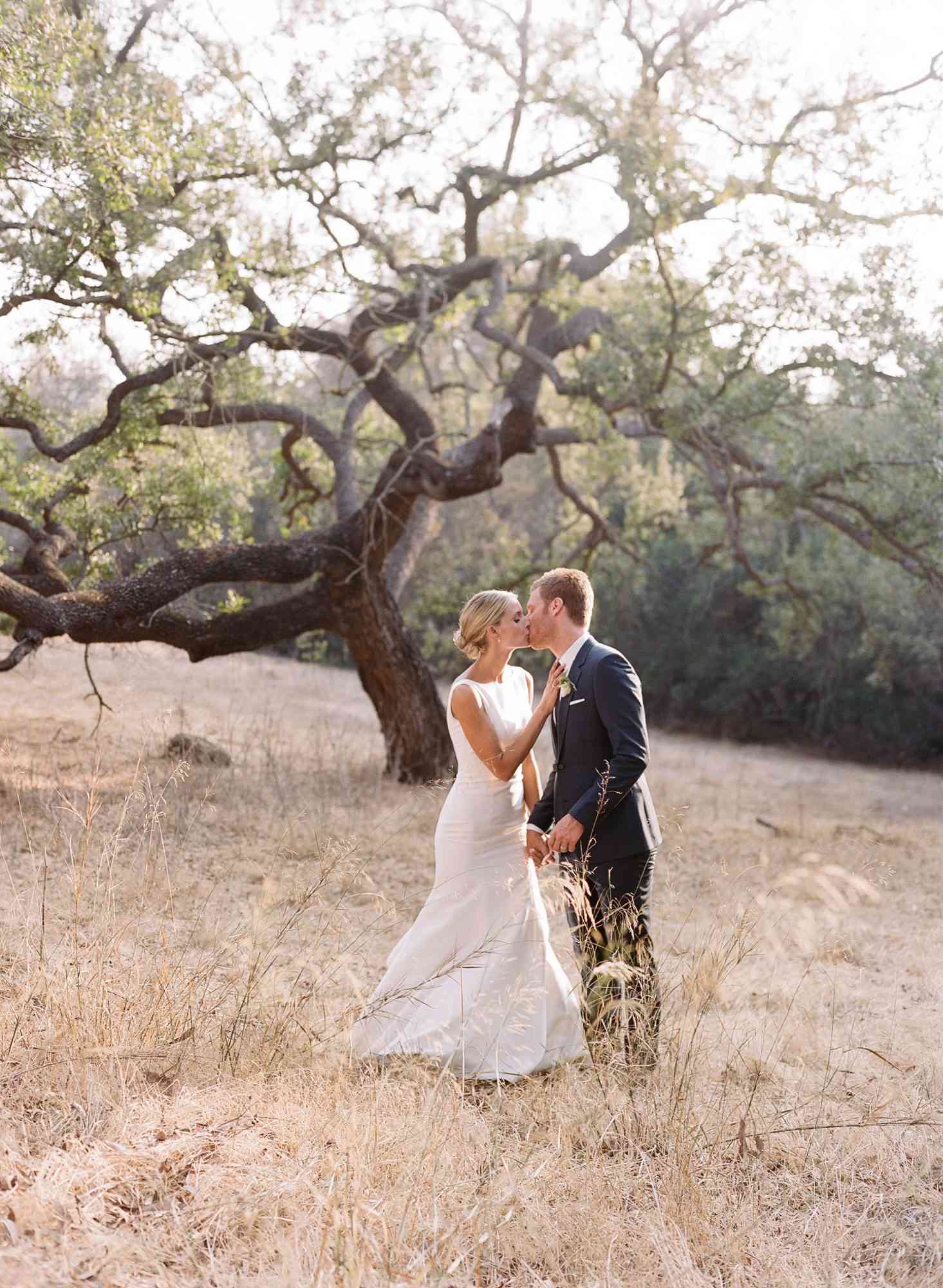 ashlie adam alpert wedding couple kissing in front of tree