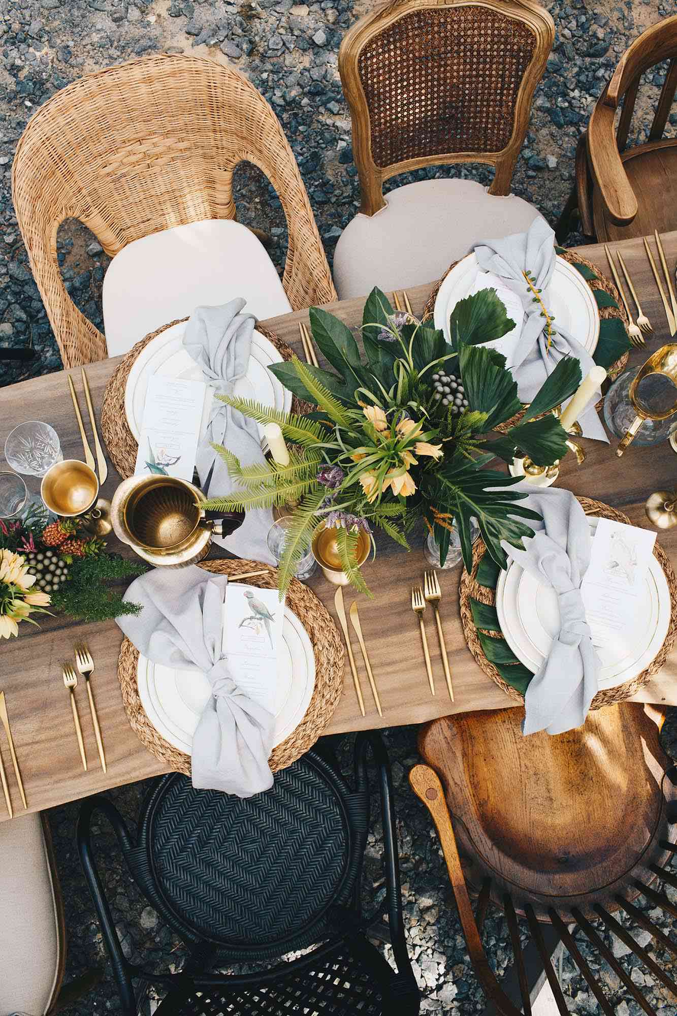 tablescape with rattan accents and tropical floral arrangements