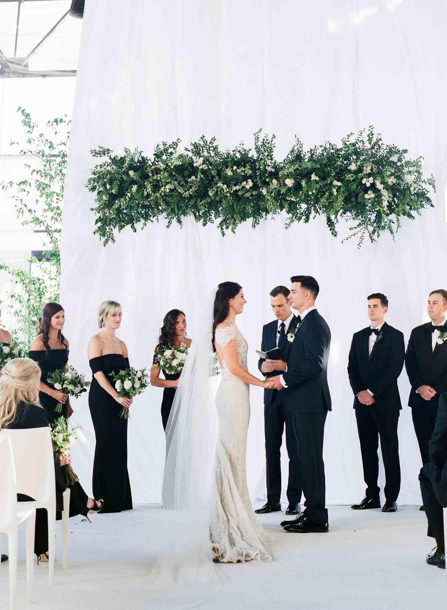 couple at religious wedding ceremony with greenery overhead