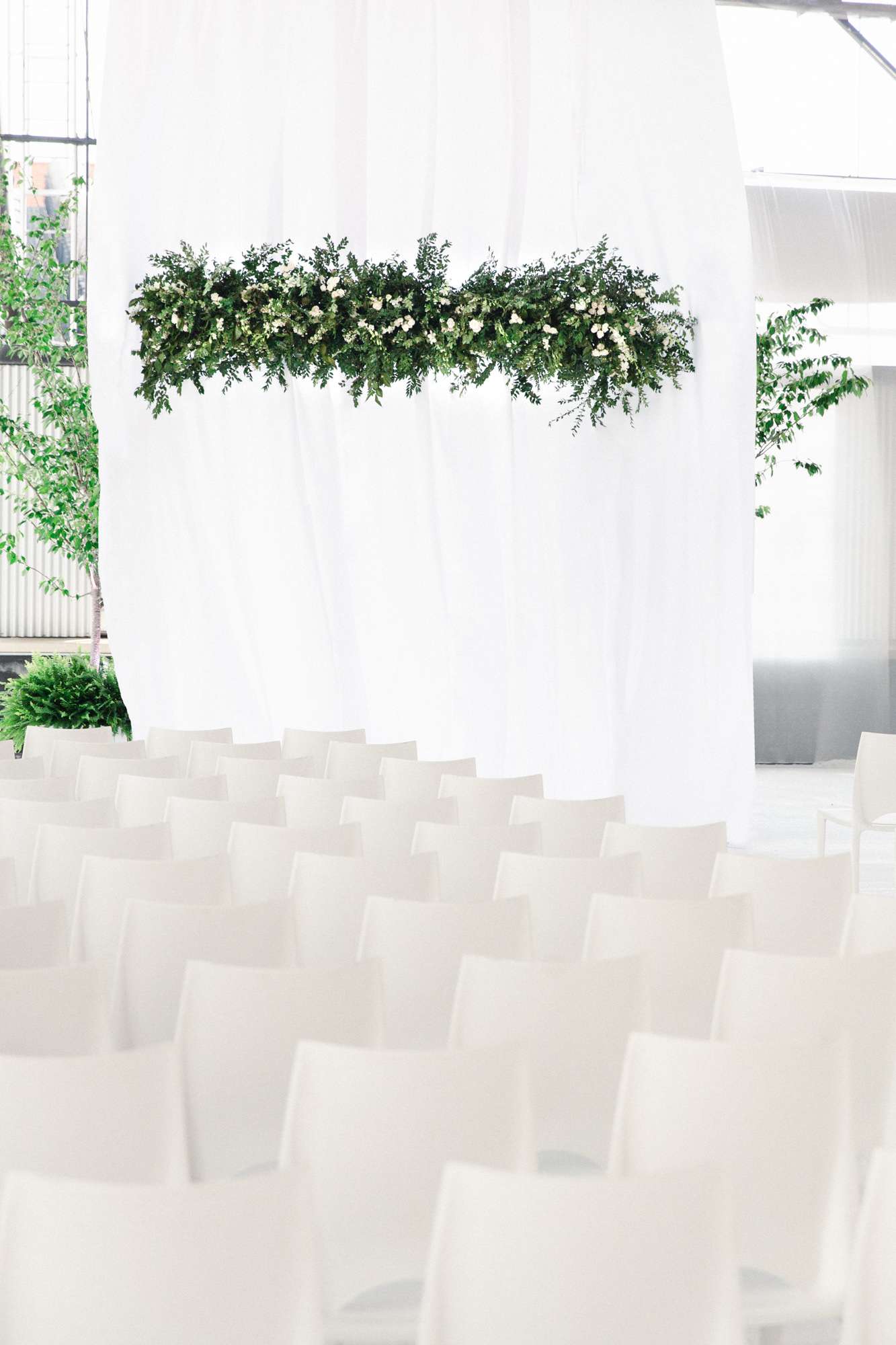 modern ceremony space with greenery chandelier