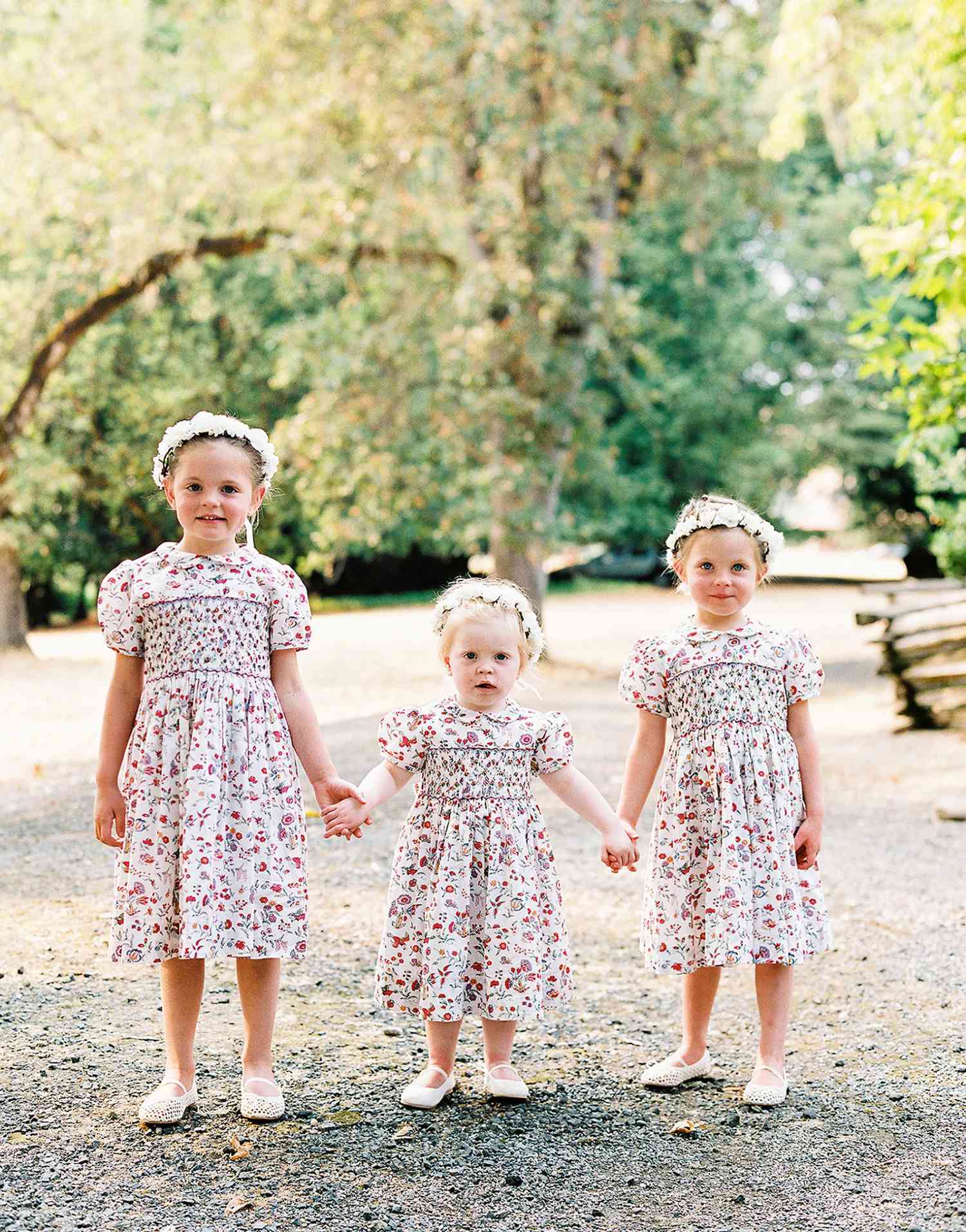 three flower girls wearing floral dresses