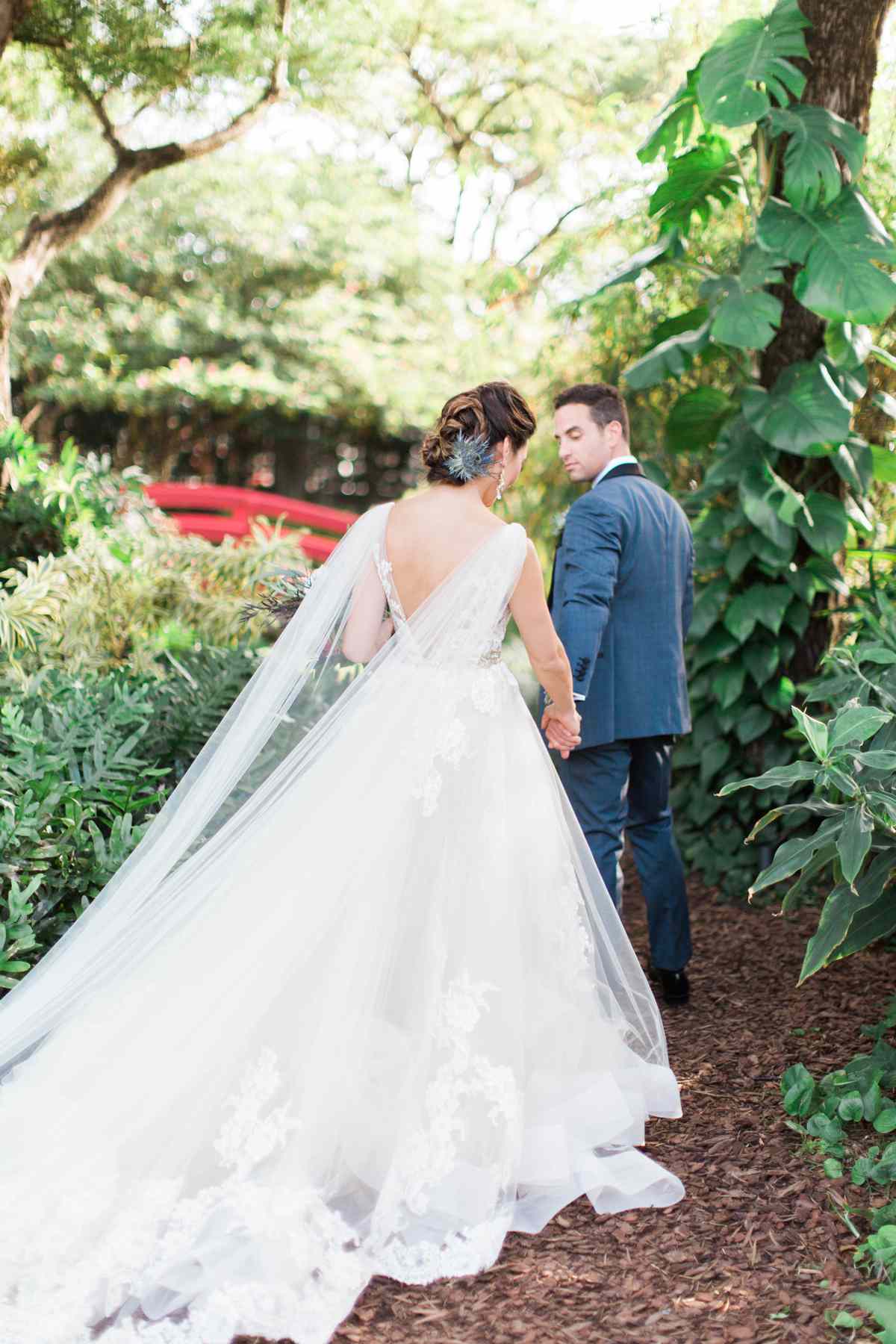 bride and groom walking away surrounded by greenery