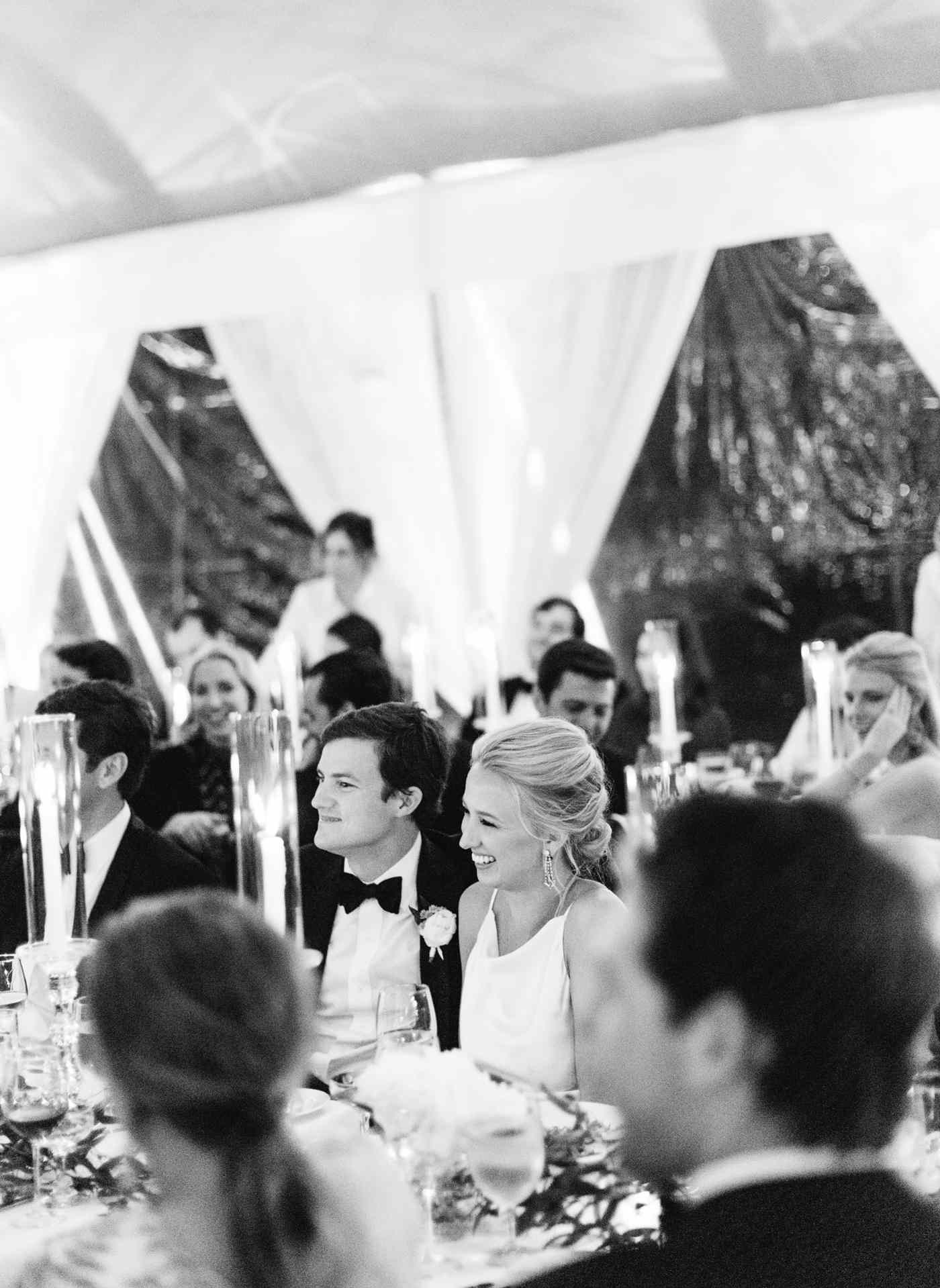 bride and groom listen to toasts during reception