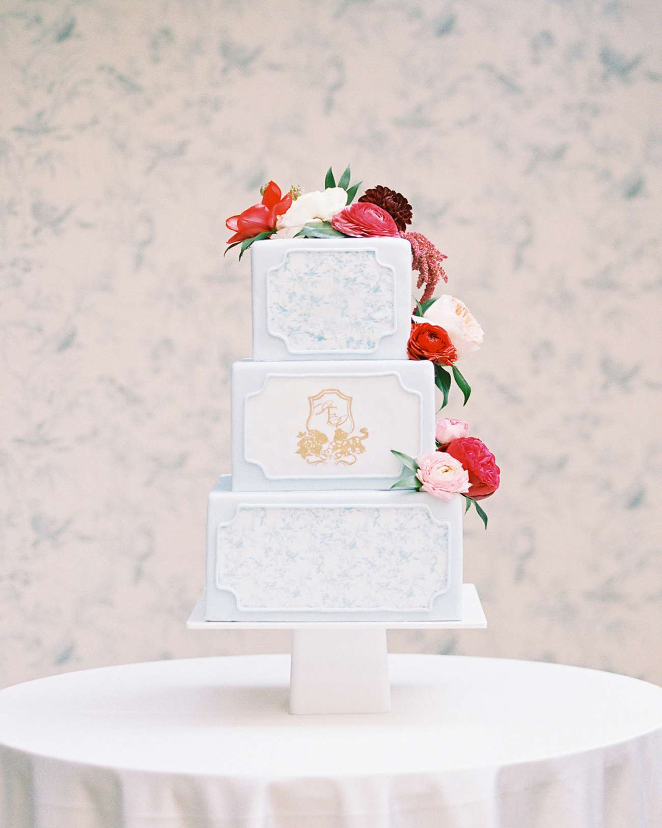 three tiered white wedding cake with floral topper