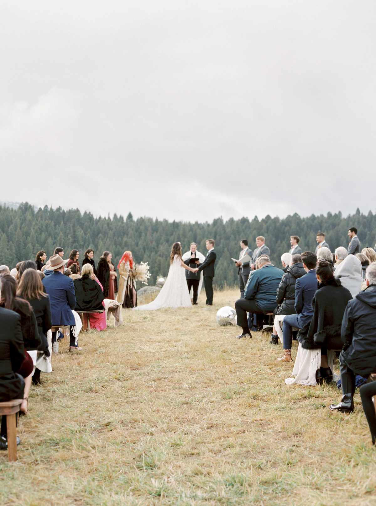 outdoor wedding ceremony with pine trees in background