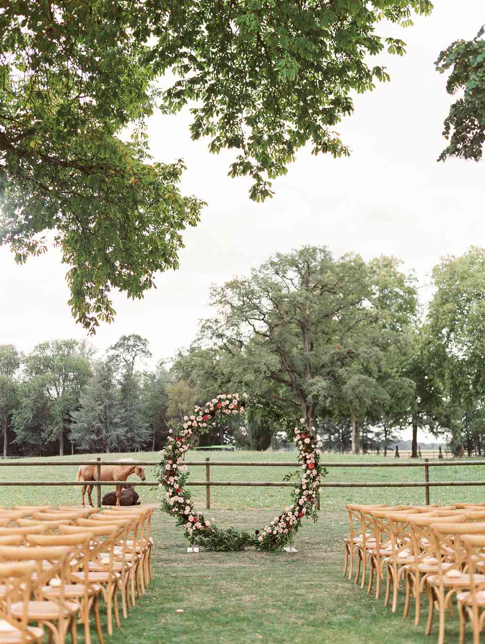 circular floral alter outdoors in front of horse pasture