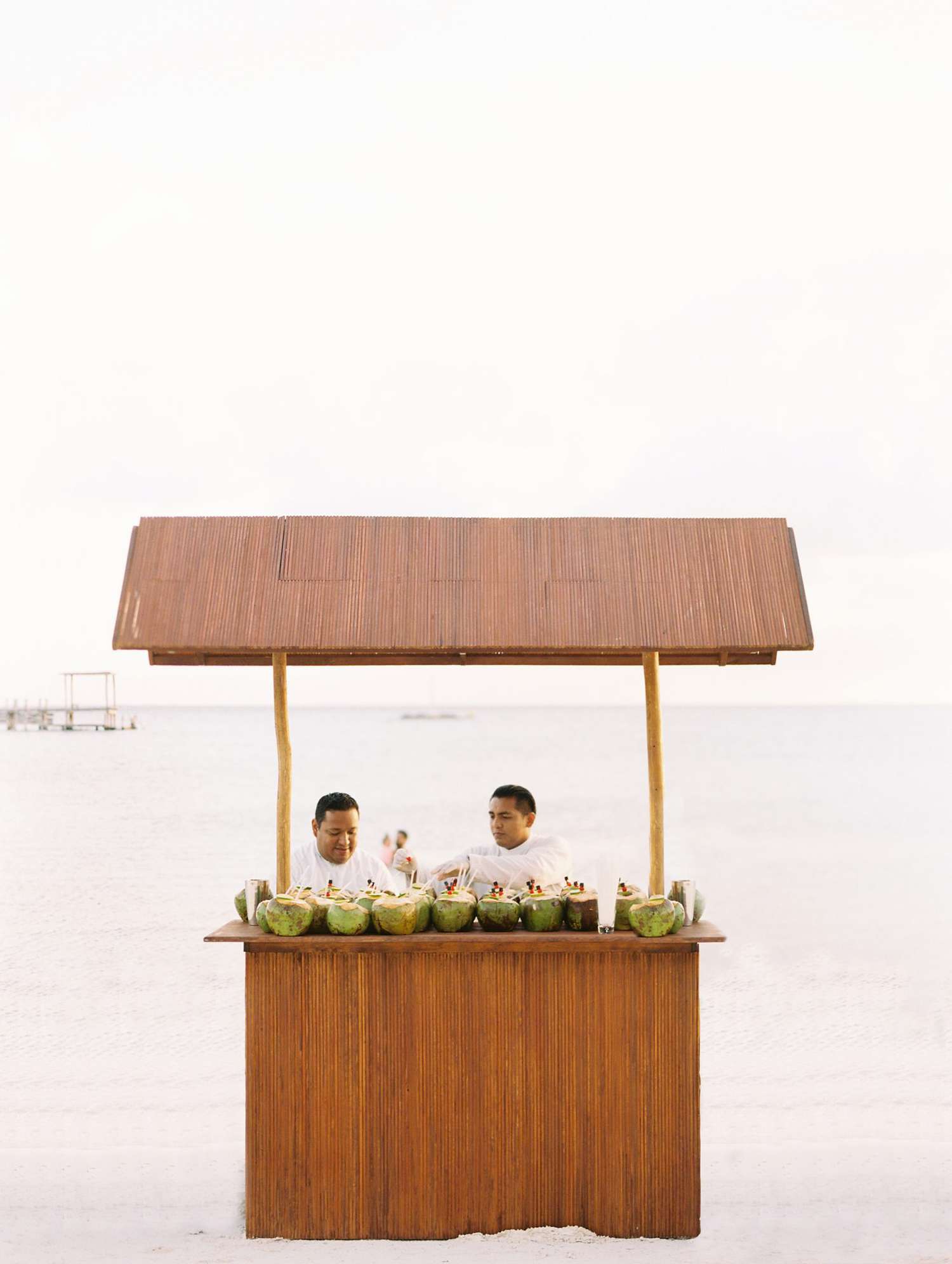 sara danny mexico wedding couple coconut stand on beach