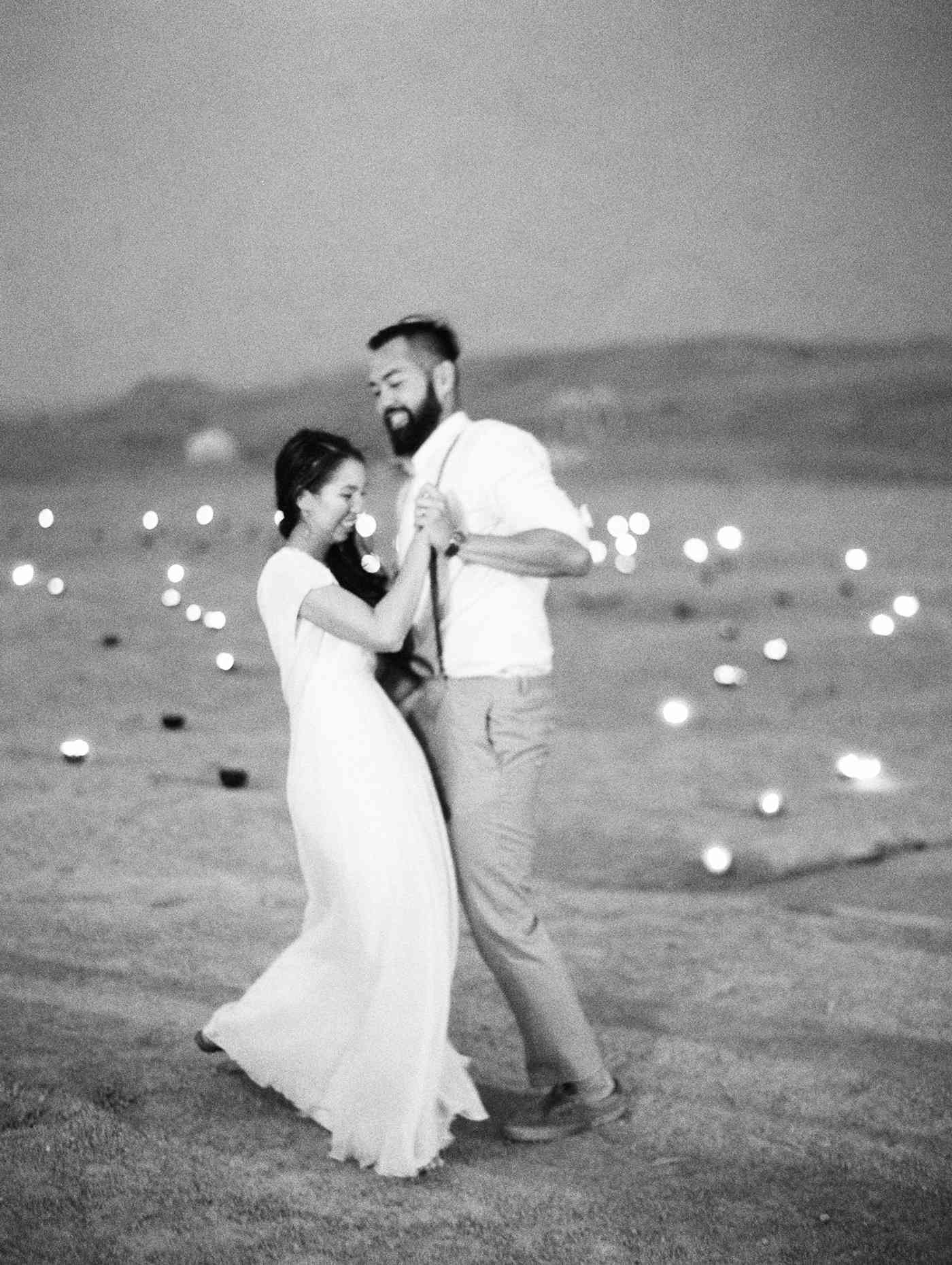 bride and groom share first dance in the desert surrounded by candles