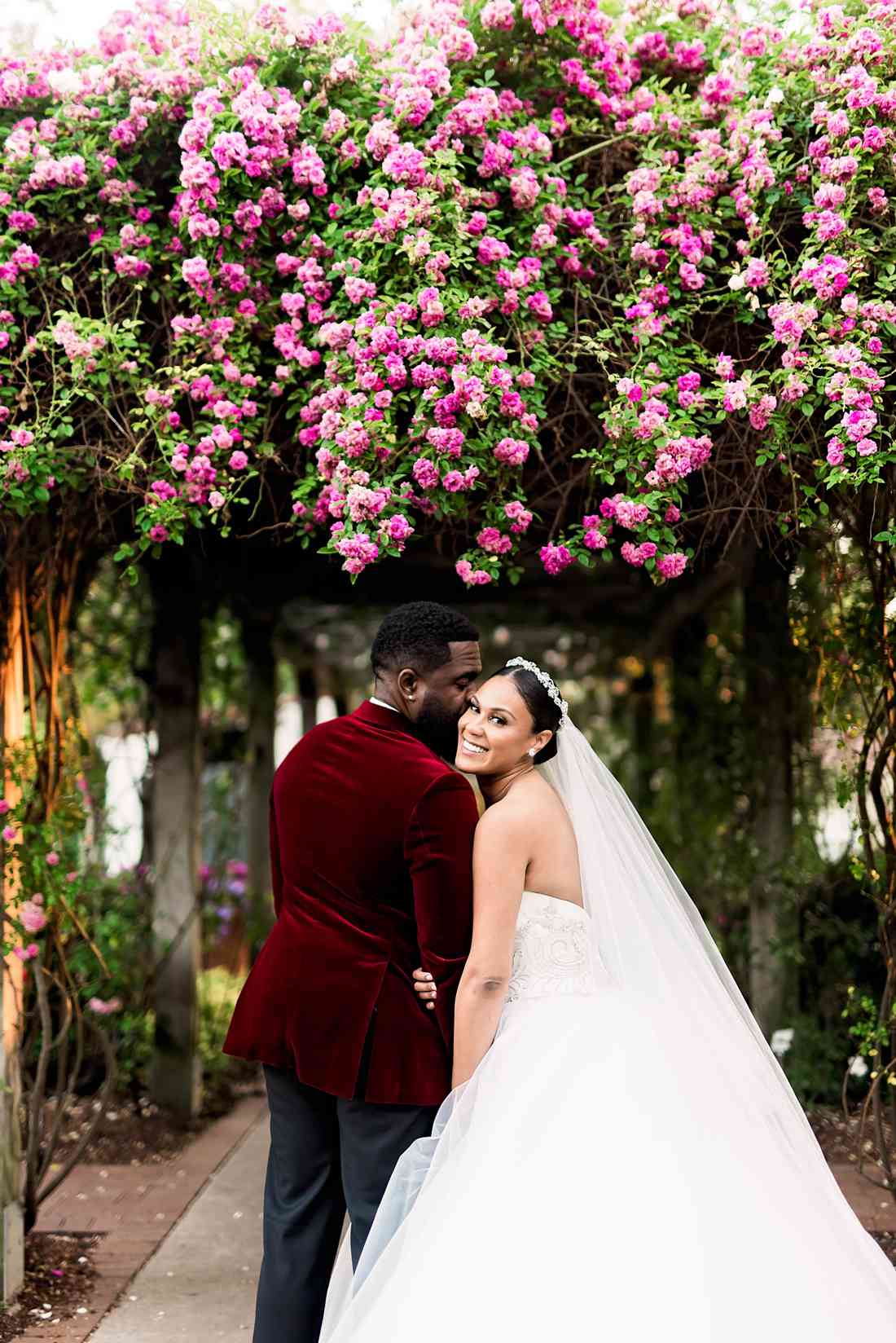 bride and groom pose in botanical garden