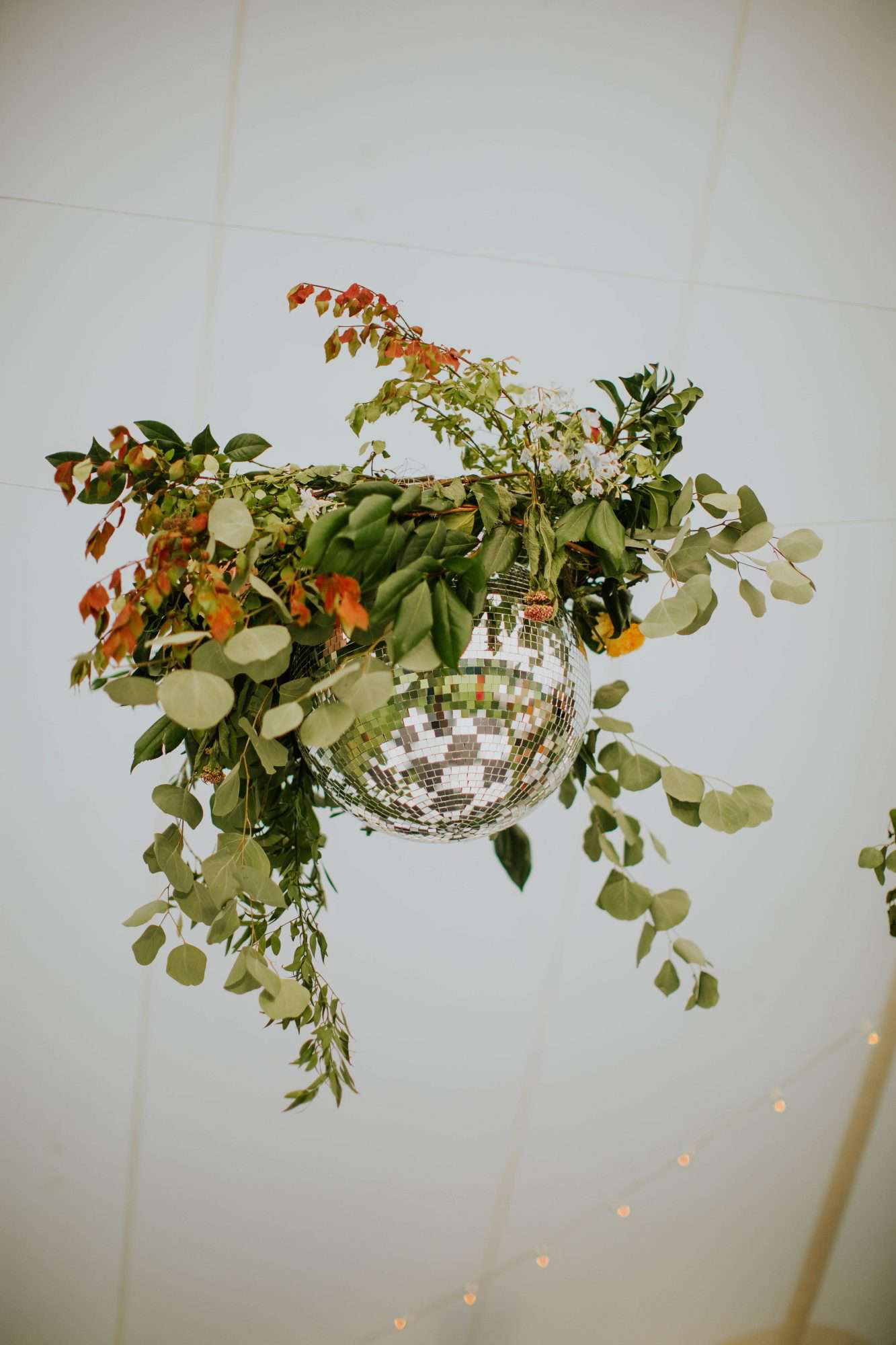 disco ball intertwined with greenery and florals