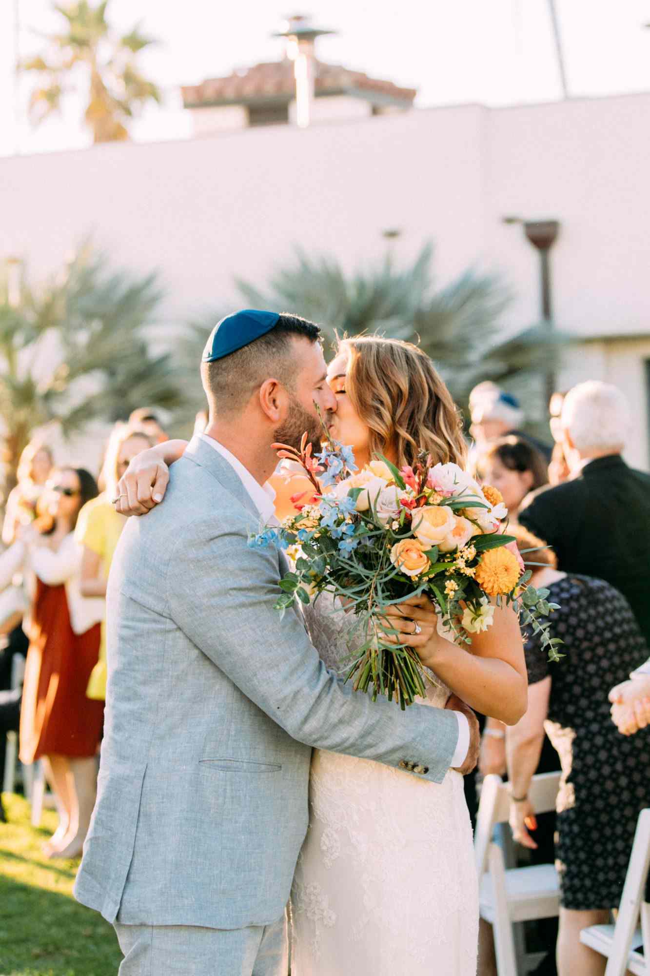bride groom wedding kiss wearing blue yarmulke