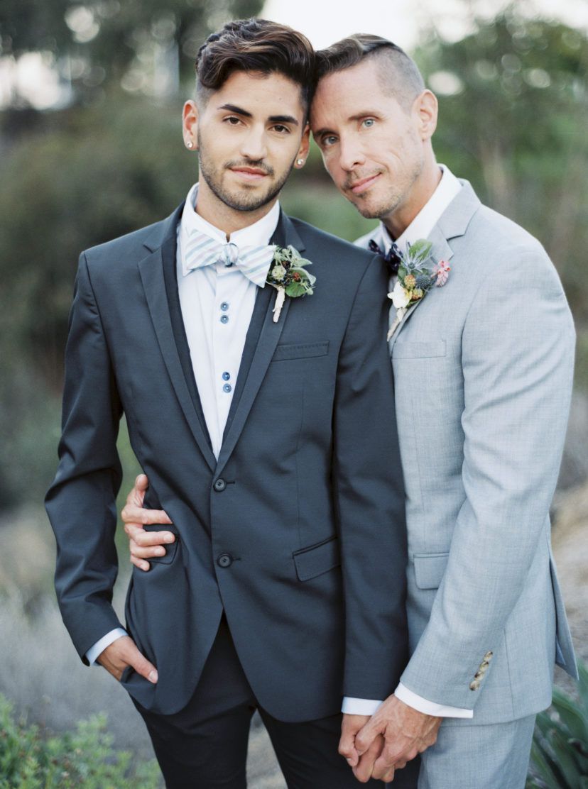 grooms wearing opposite gray shade color suits with printed bow ties