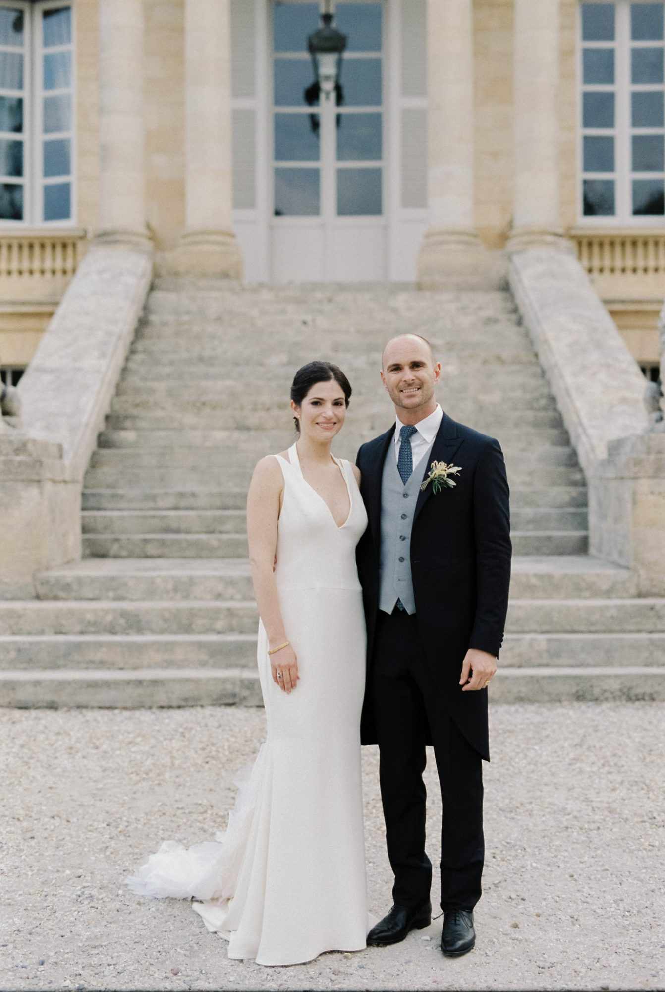 bride and groom pose outside Chateau La Louviere wedding venue