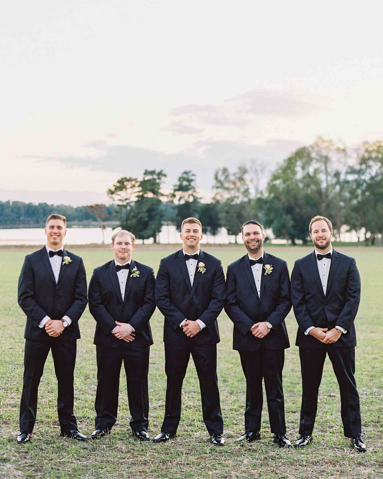 groomsmen posing tuxedos outdoors