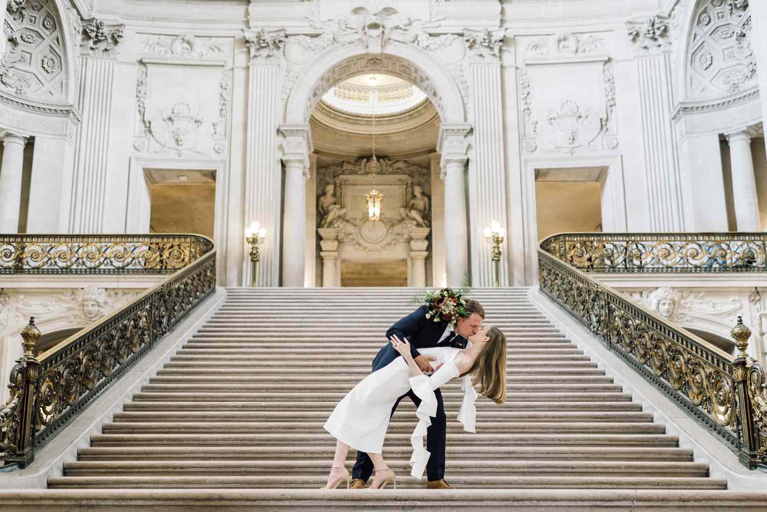 groom dips bride on city hall steps
