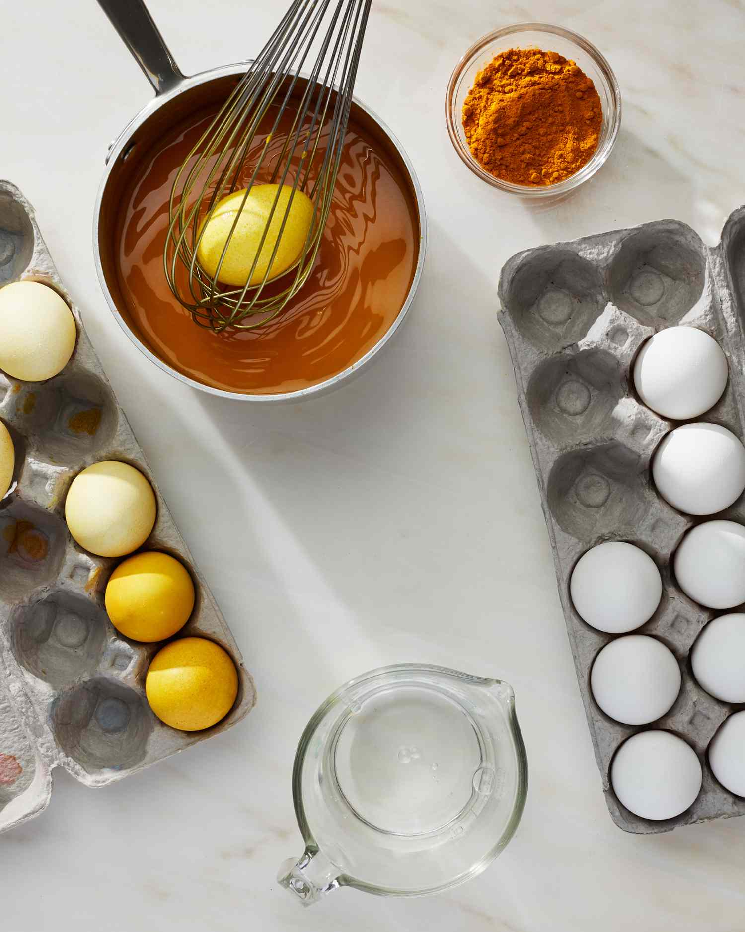 whisking an egg in a pot with orange dye