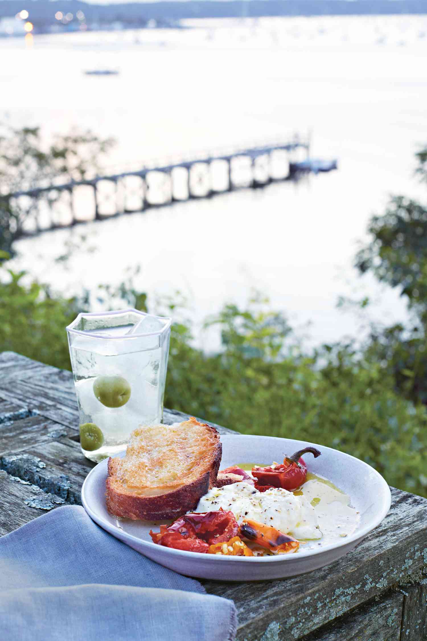 grilled bread and chiles with burrata placed on an outdoor picnic table