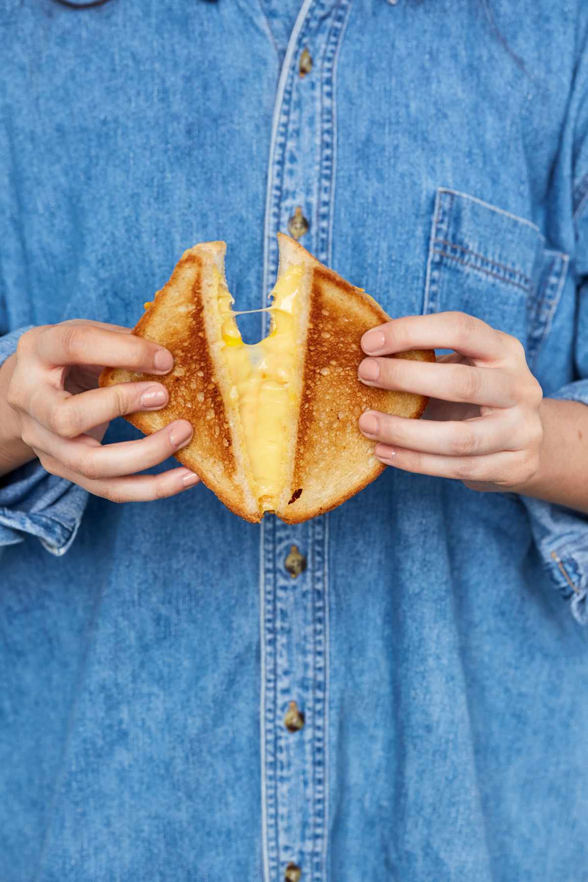 hands holding grilled cheese