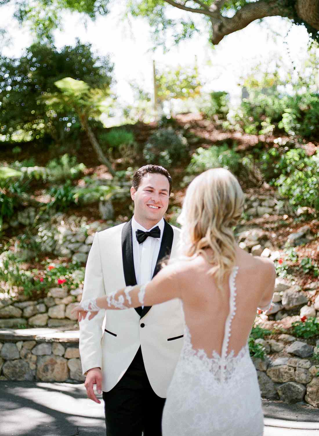 groom smiles at bride during first look