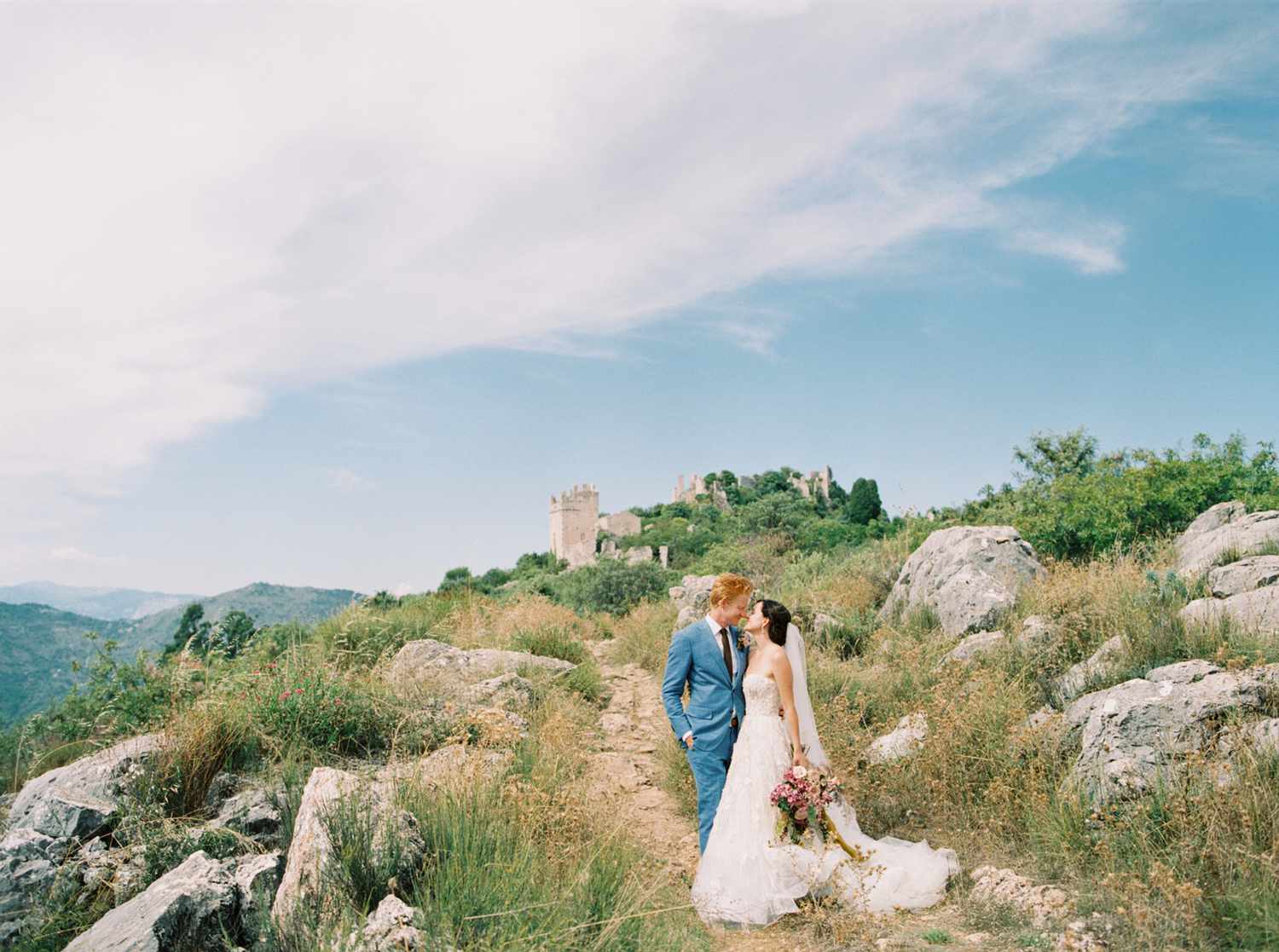 bride and groom stand on hillside south of france venue