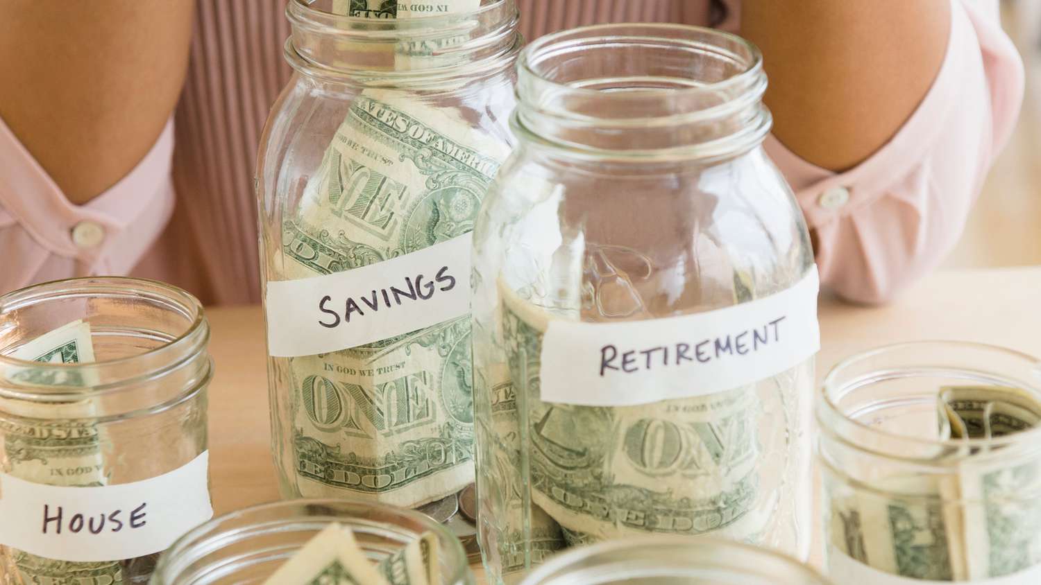 woman saving money in jars