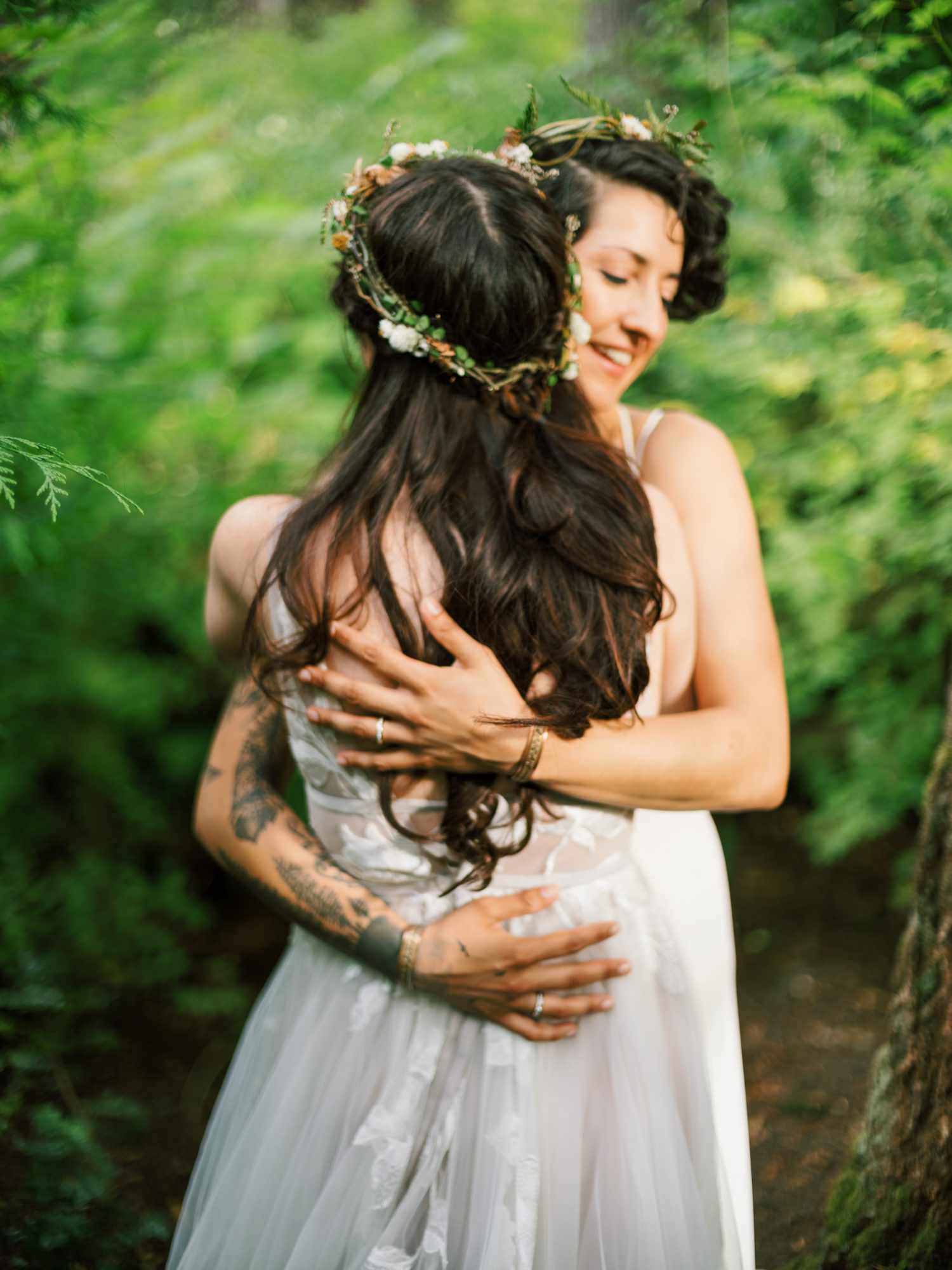 brides hugging during wedding portraits outside in forest
