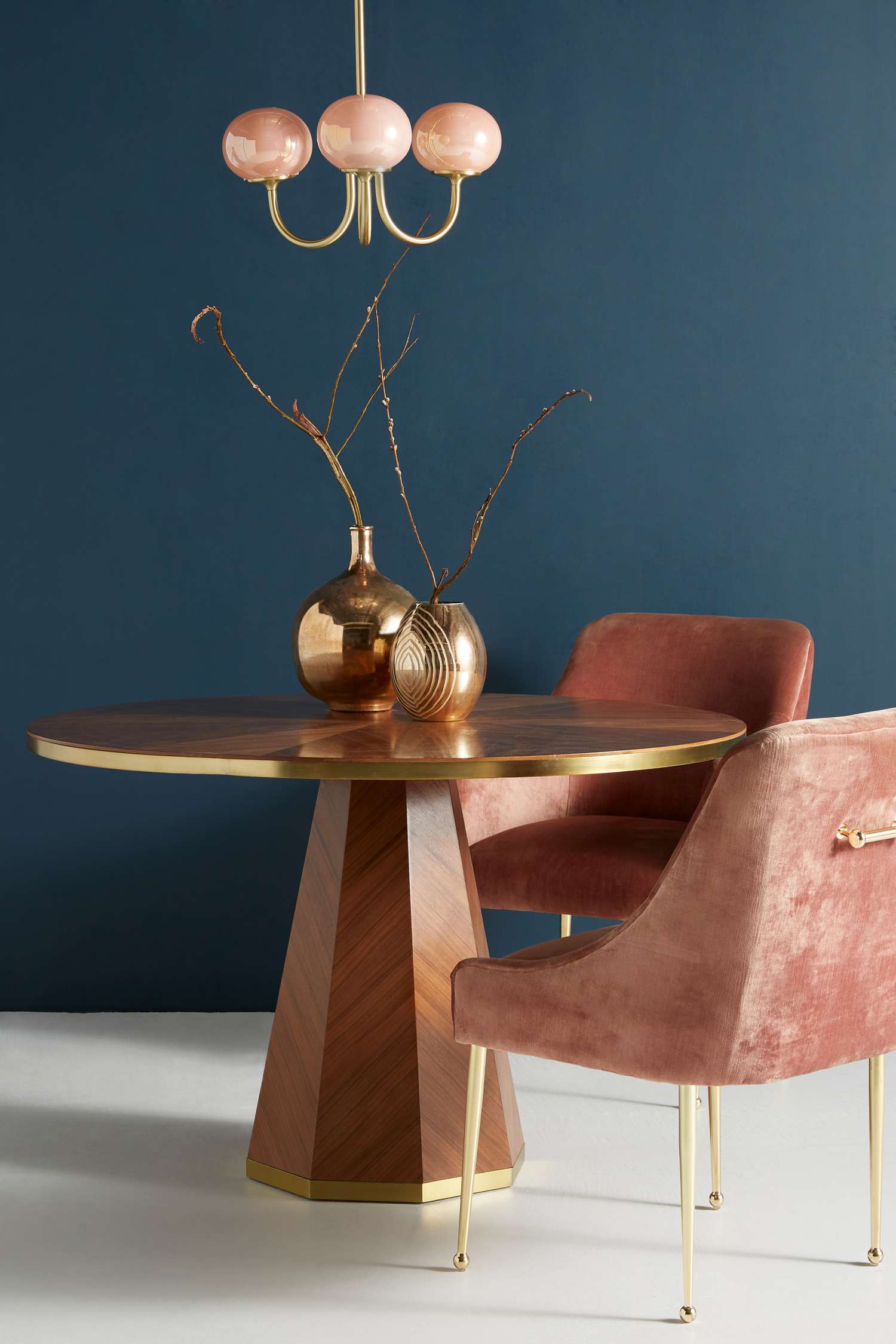 gold and wood dining table in dark blue room