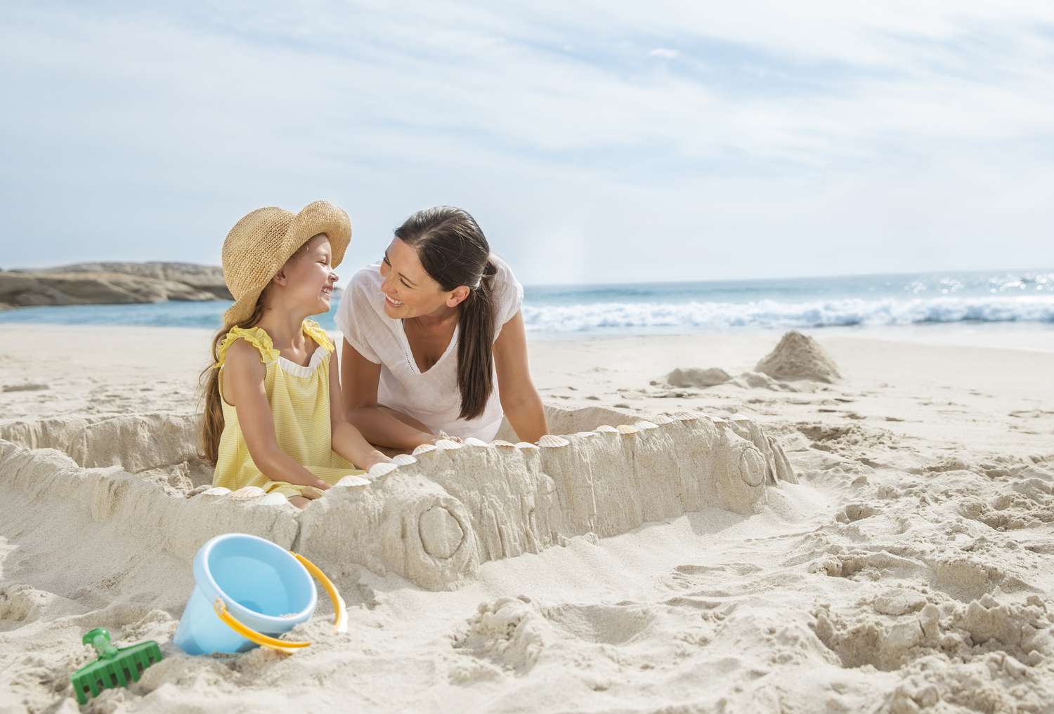 Mom and Daughter Building a Sandcastle on the Beach