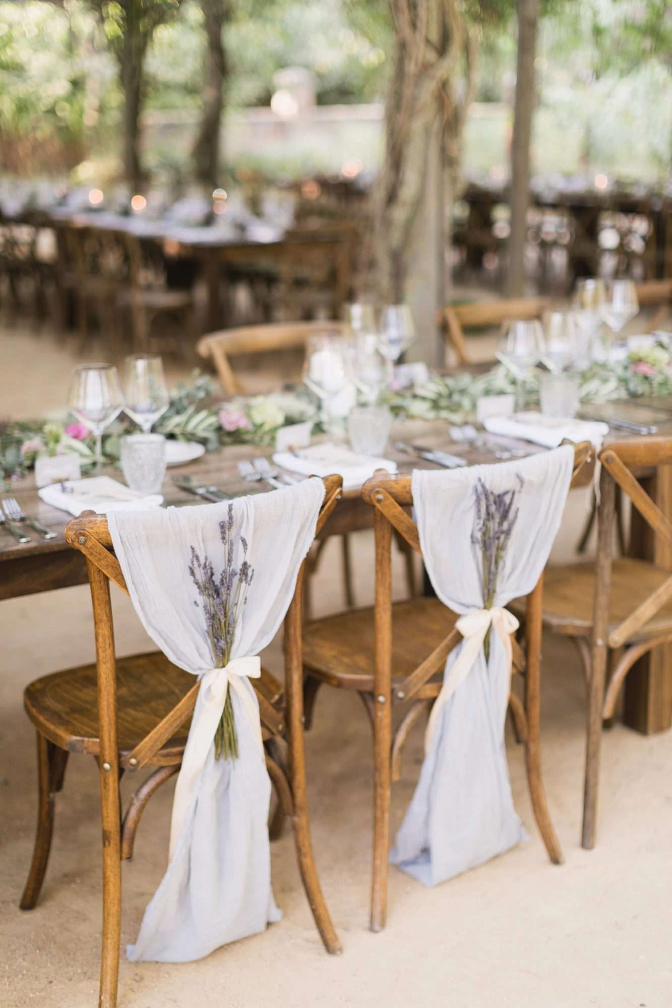lavender bouquets tied to sheer fabric on reception chairs