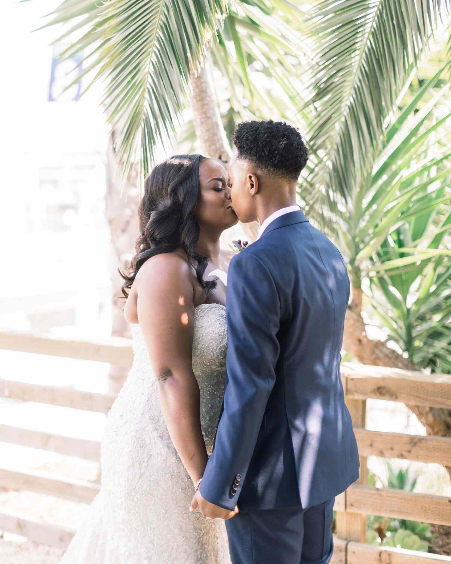 outdoor wedding kiss under tropical tree