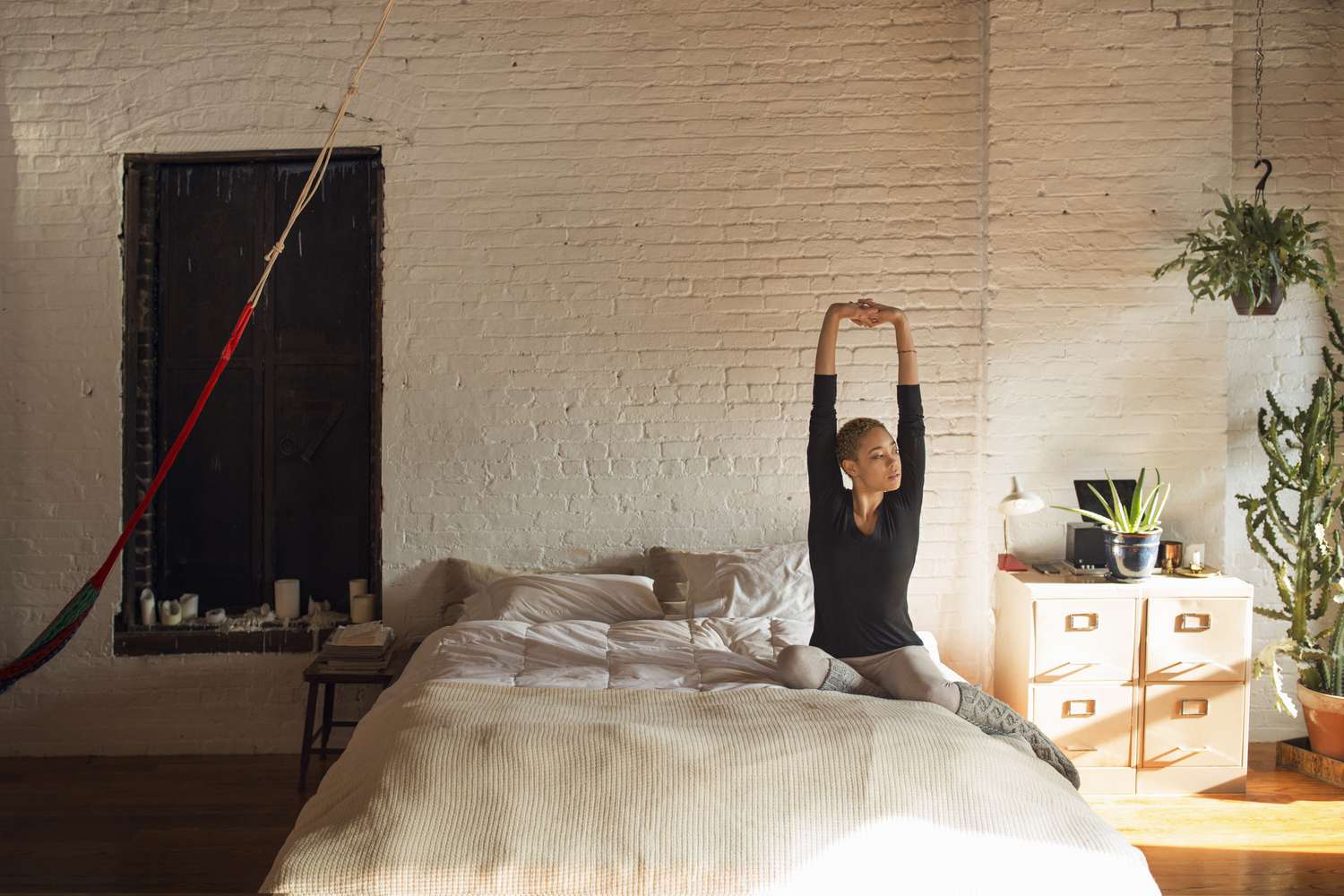 Woman waking up and stretching in bed