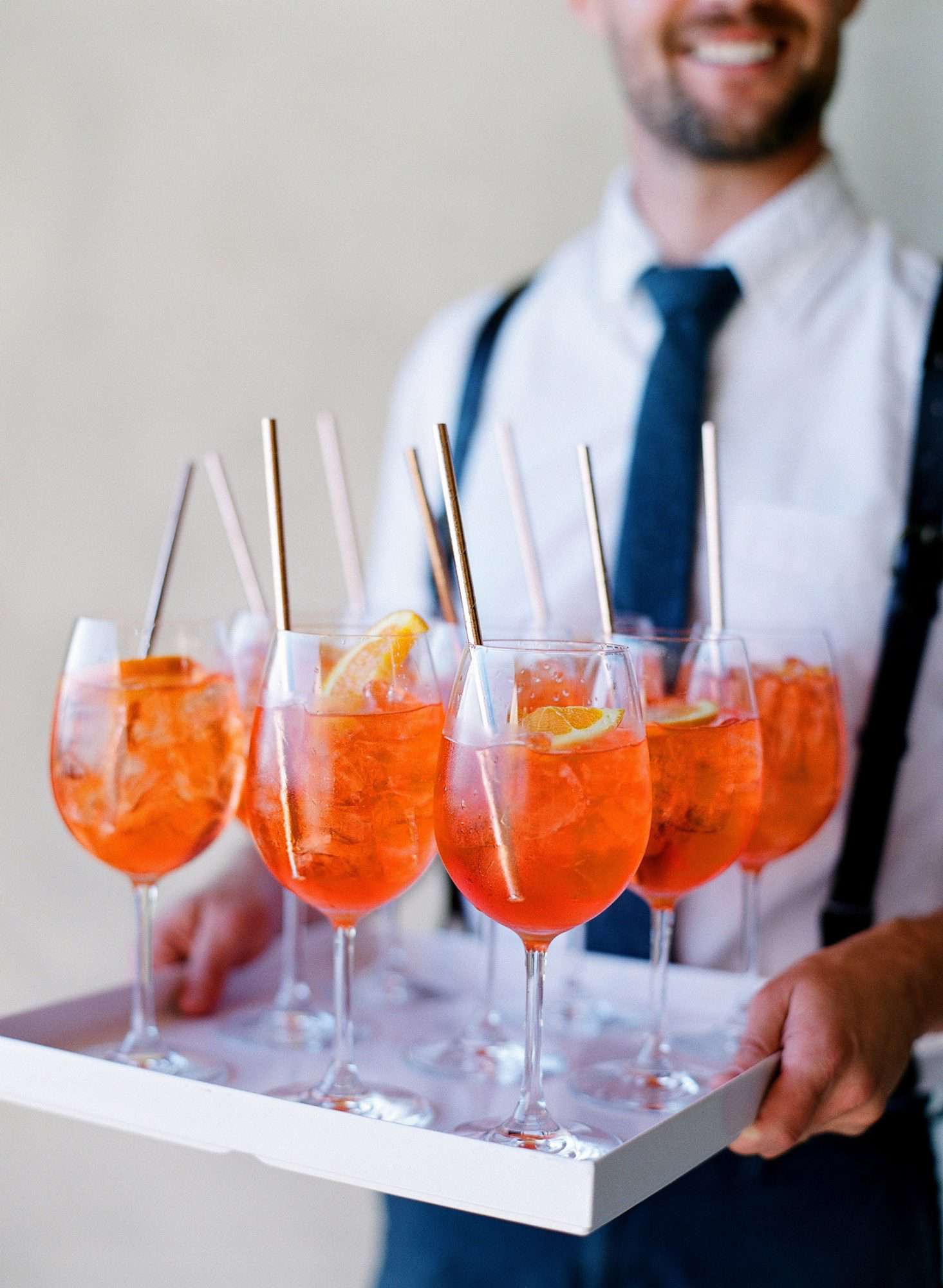 man carrying tray of aperol-spritz