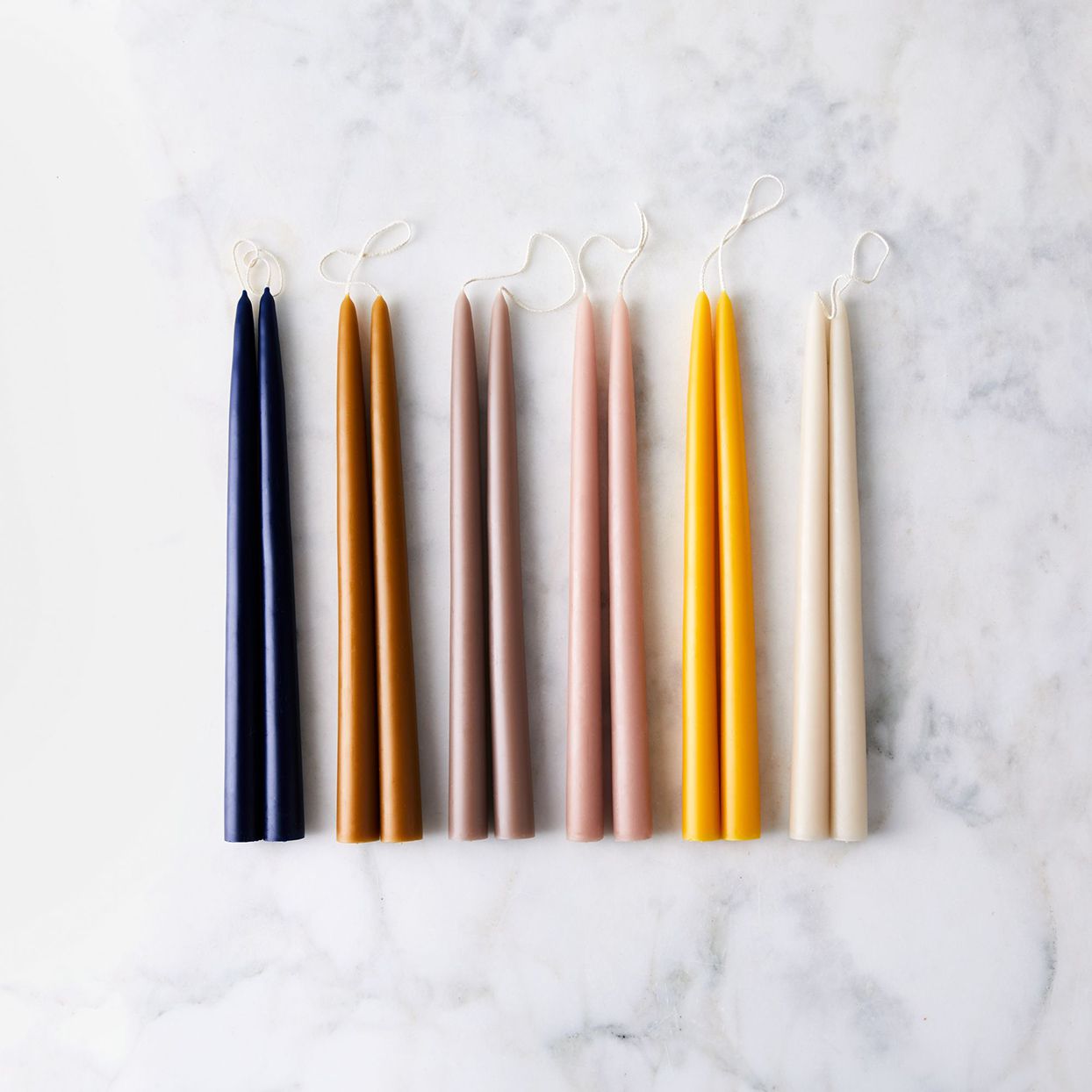shimmering taper candles on marble surface