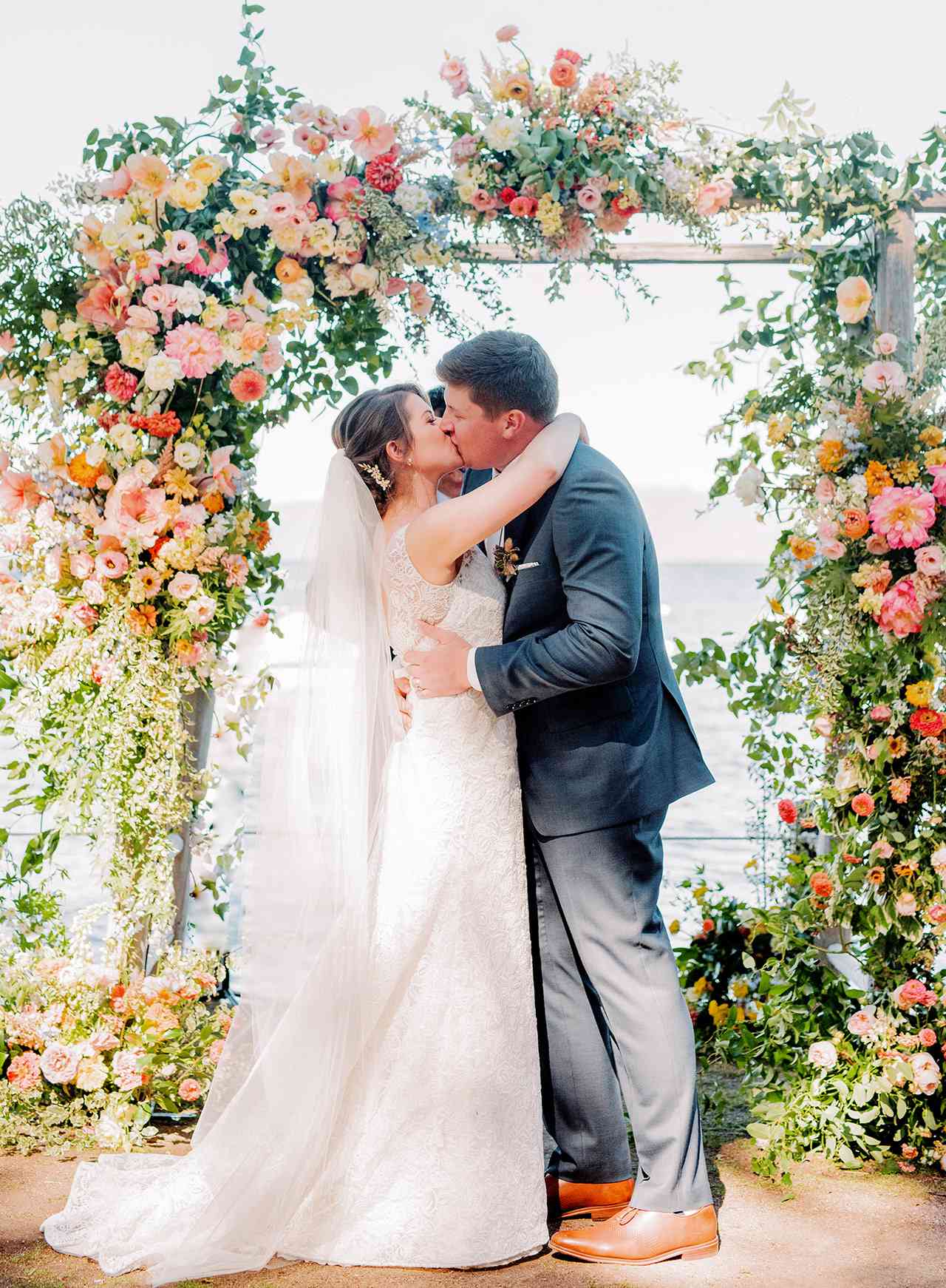 bride groom wedding kiss lake view under arch