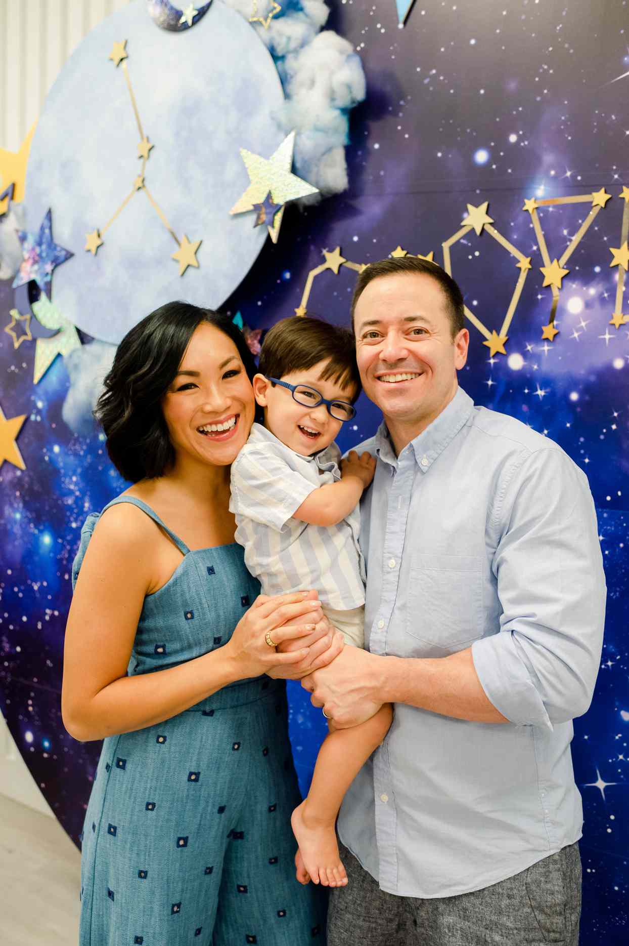 parents and kid at celestial themed birthday party smiling