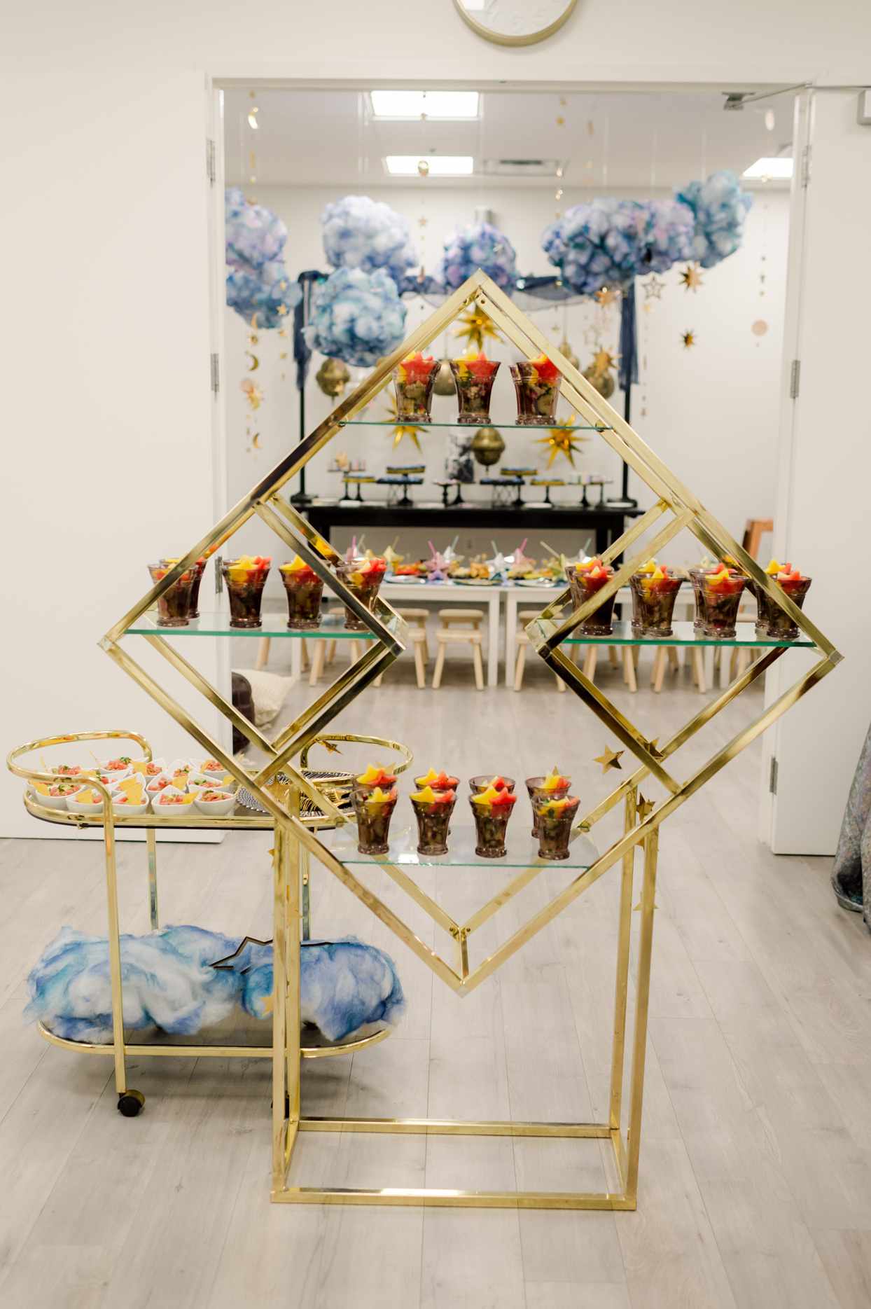 golden framed display serving table and cart with galaxy themed party snacks