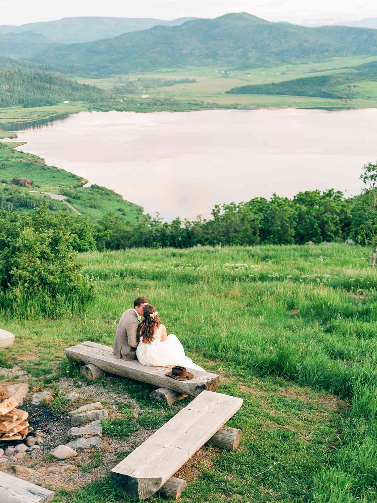 logan conor wedding couple sitting on bench overlooking mountains