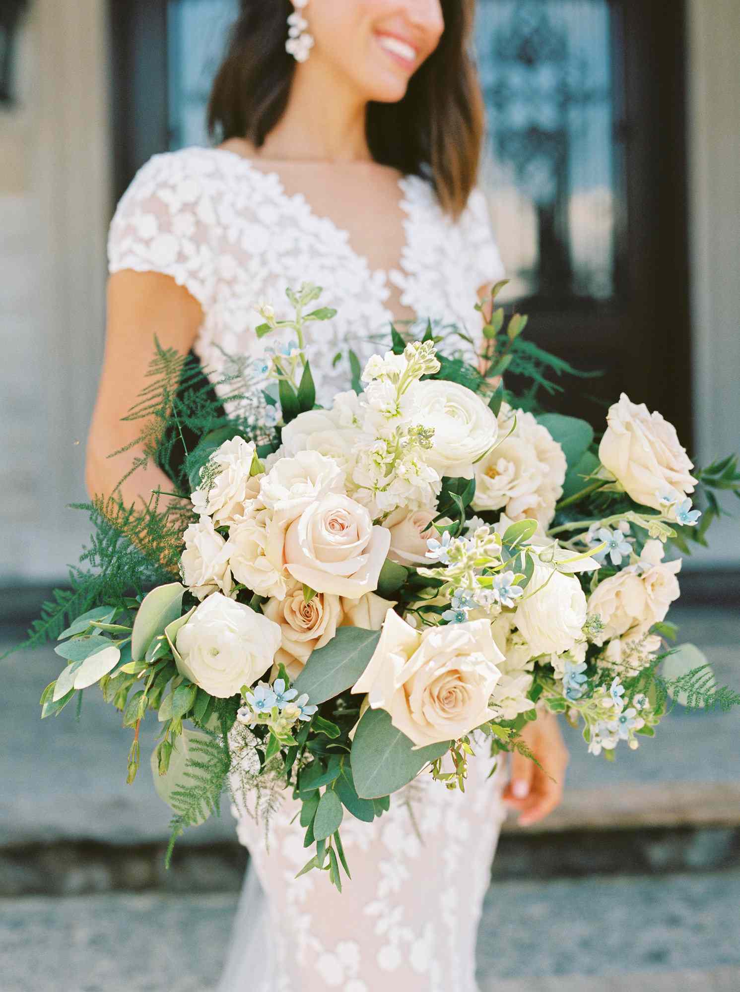 roses, ranunculus, blue tweedia, and greenery bridal wedding bouquet