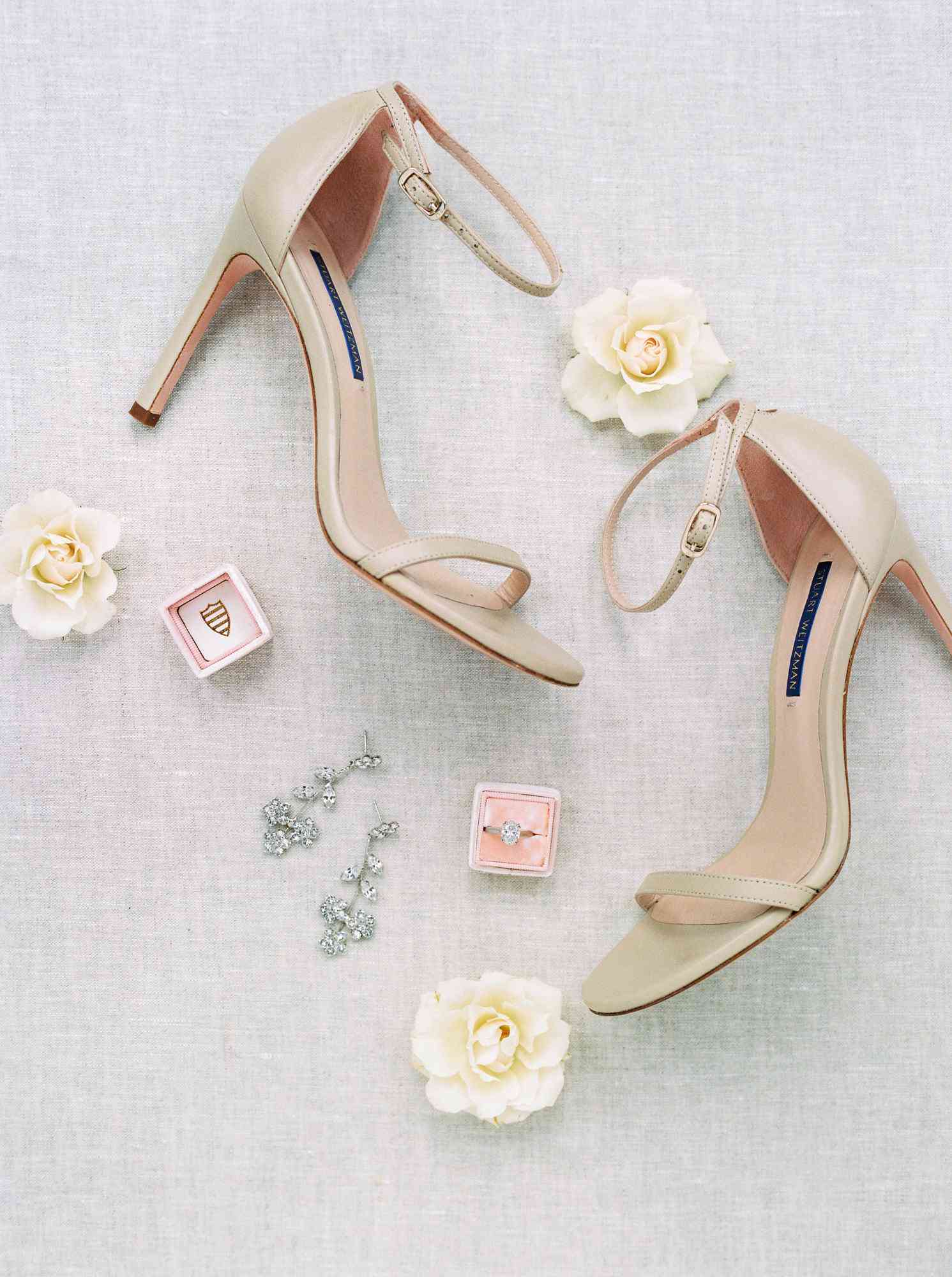 nude ankle-strap Stuart Weitzman heels with dangly diamond and silver earrings