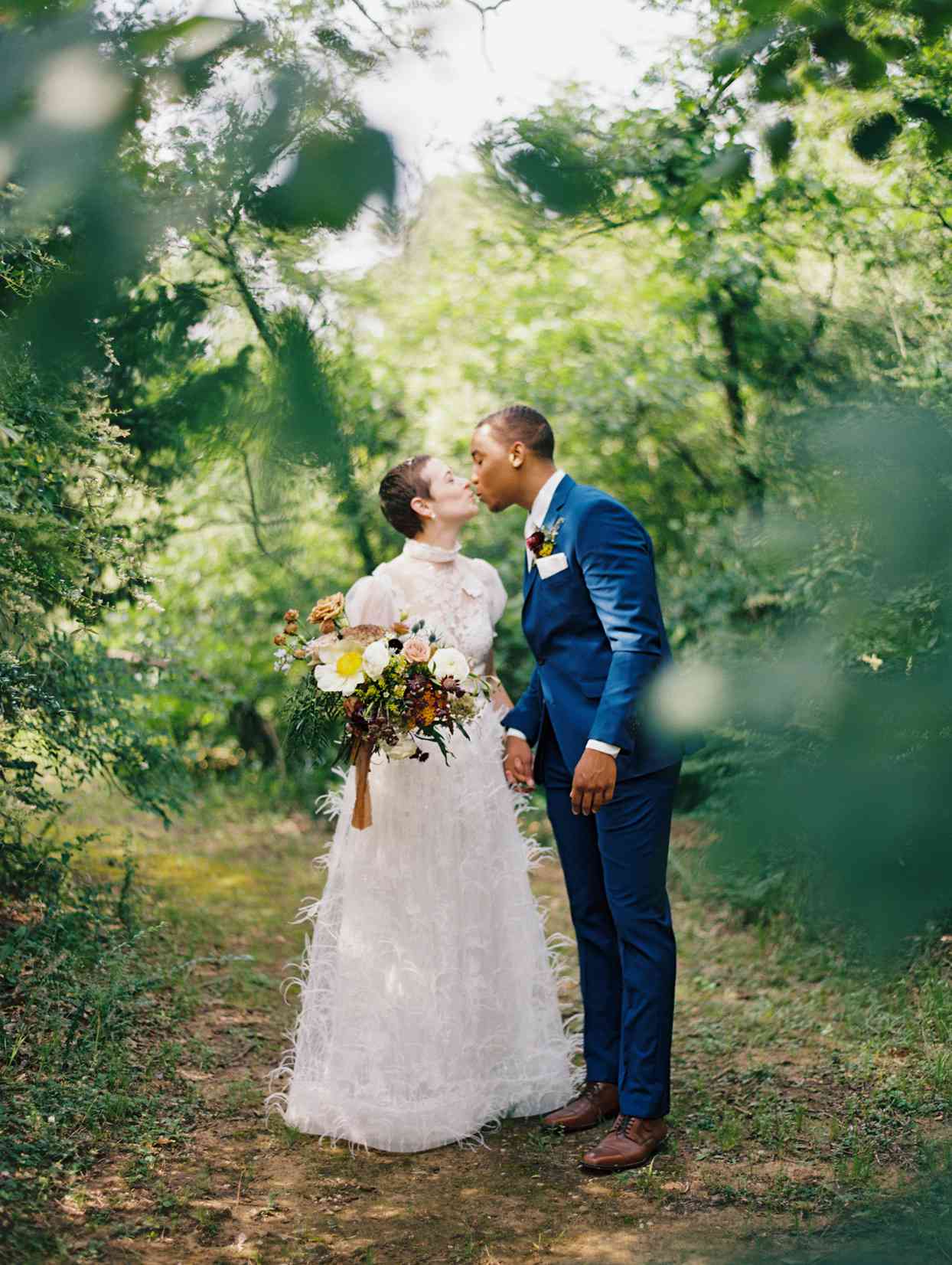 Wife and husband kissing in wooded area