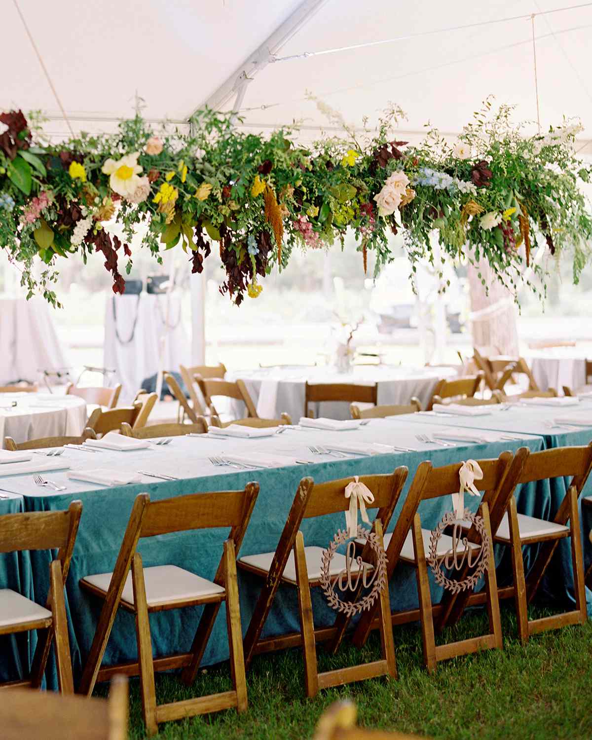 Picnic gazebo seating for wedding with folding chairs and long floral arrangement