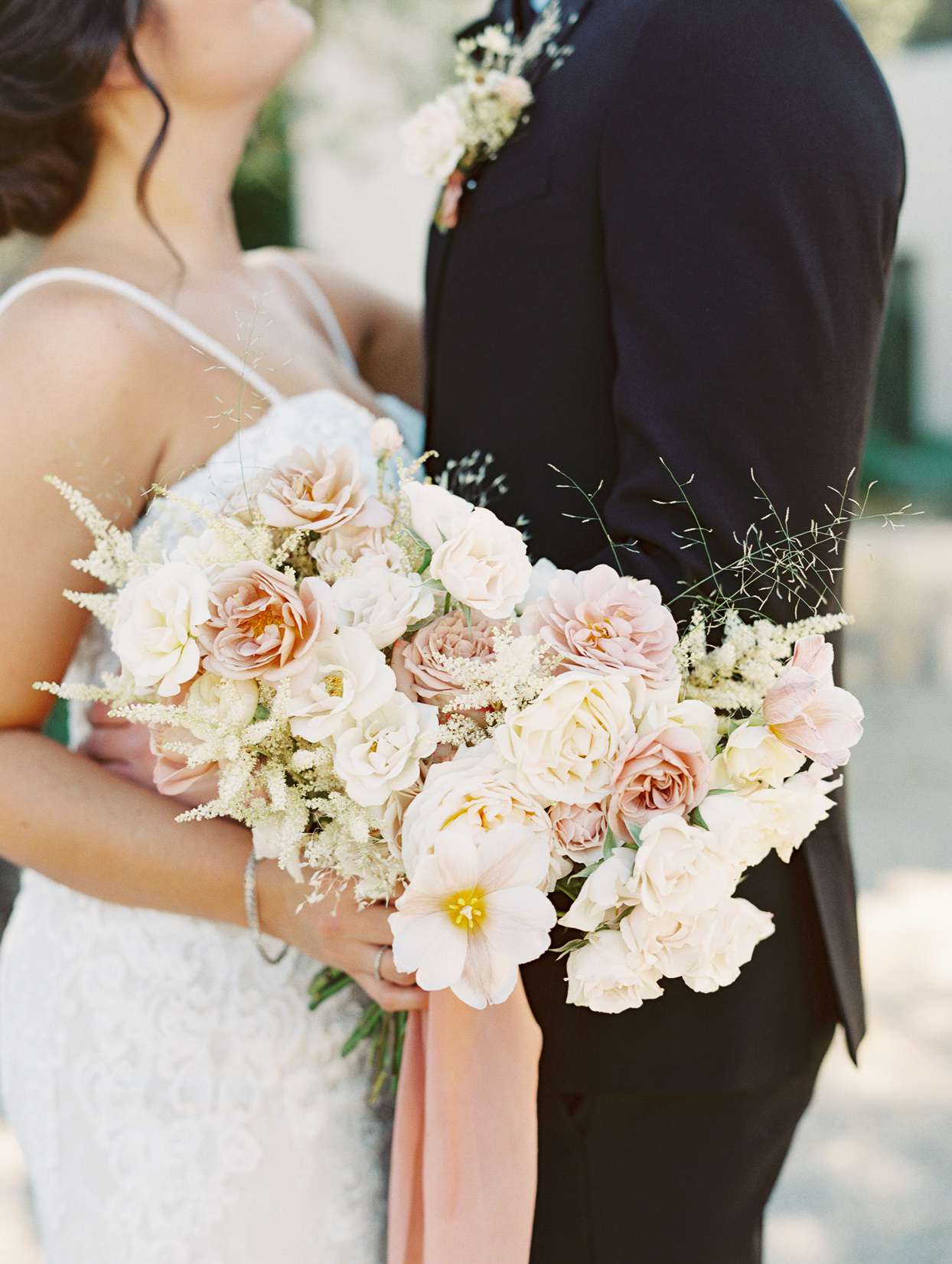 Bride holding a bouquet with Italian pit, explosion grass, garden spray roses, spray roses, garden roses, tulips, carnations, astilbe, and preserved florals
