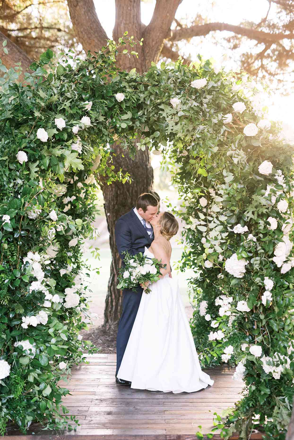 amanda will wedding couple kiss under floral arch