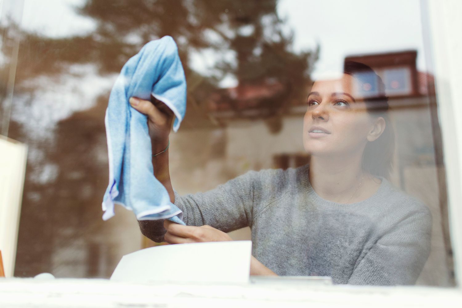 Woman cleaning window with cloth