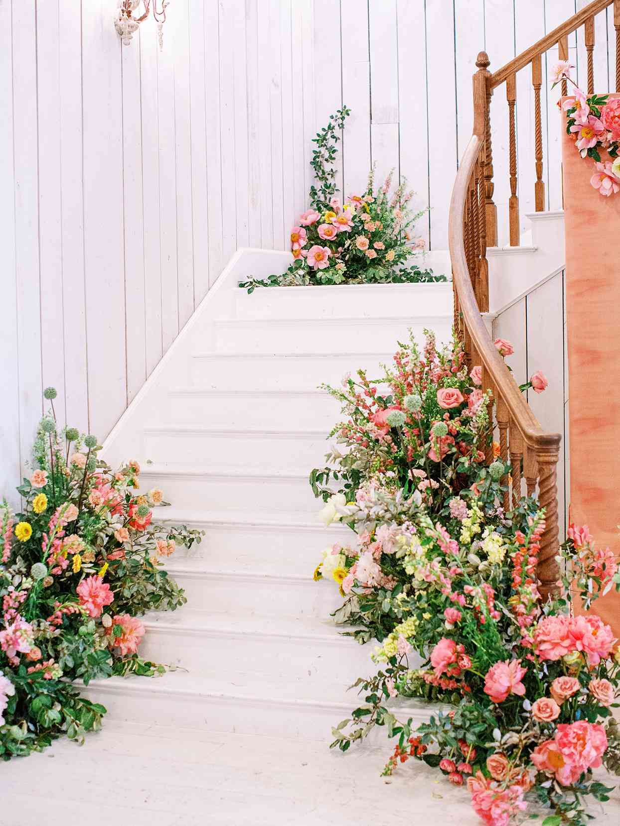 evie joe wedding reception white staircase with citrus colored florals
