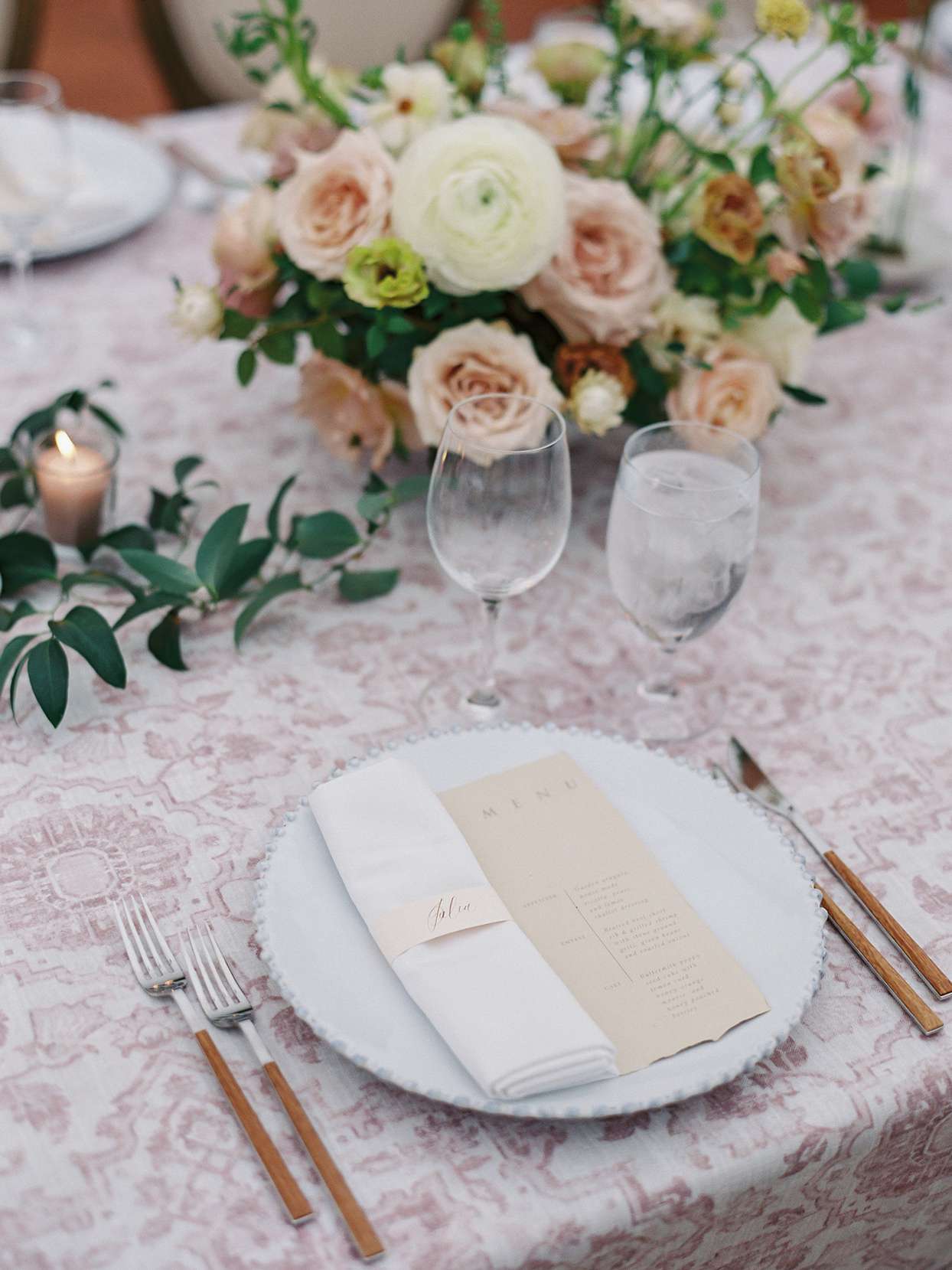 Wedding place setting with patterned linens paired with white napkins