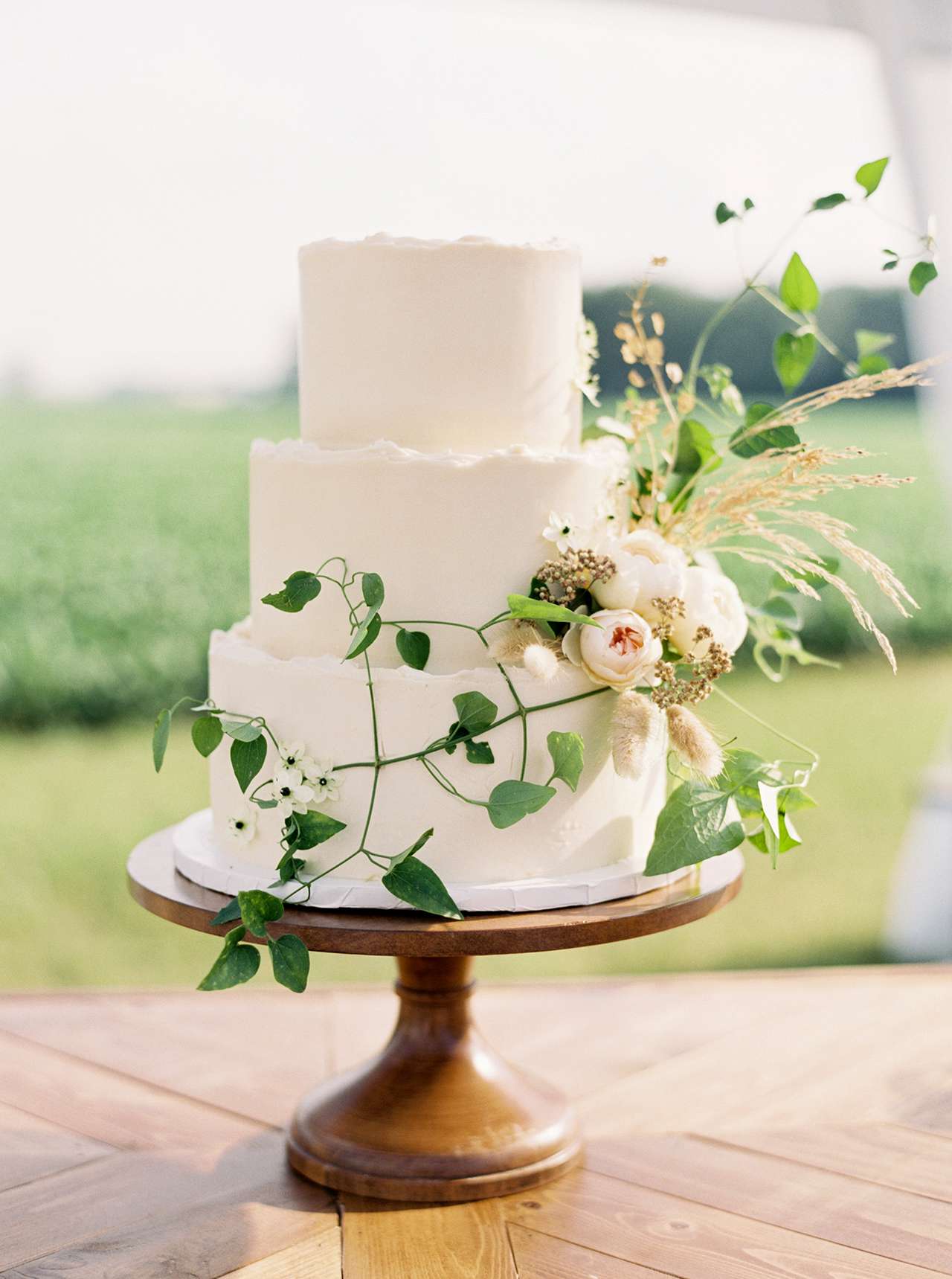 three tier wedding cake displayed on wood table