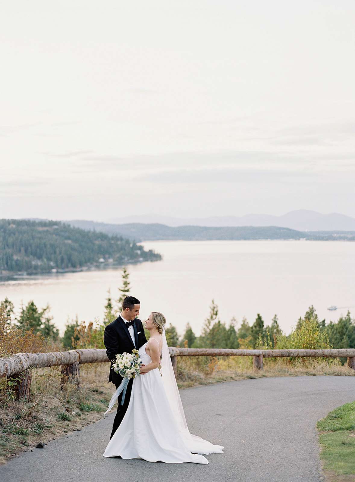 bride and groom smile standing on paved pathway outside